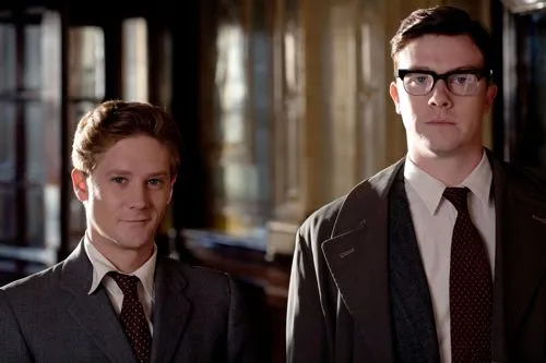 Bryan Dick as Ernie in BBC Comedy Eric and Ernie. He stands in a suit next to Eric played by Reece Shearsmith