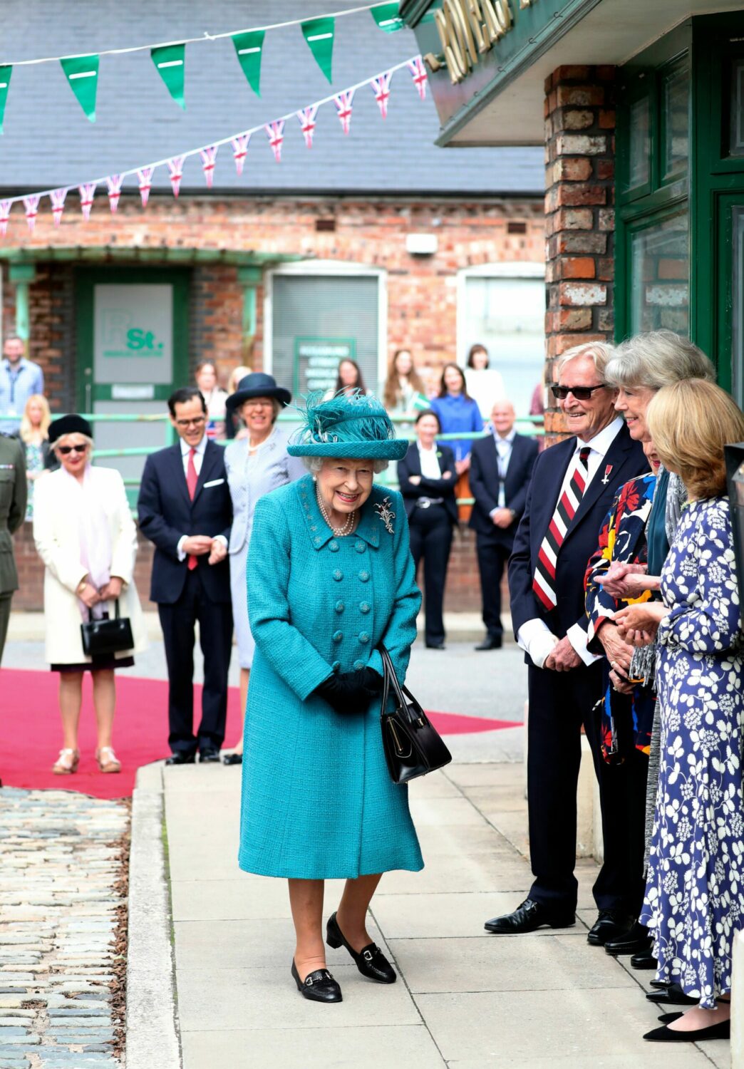The Queen walks on the famous Corrie cobbles and meets William Roache, Sue Nicholls and Helen Worth