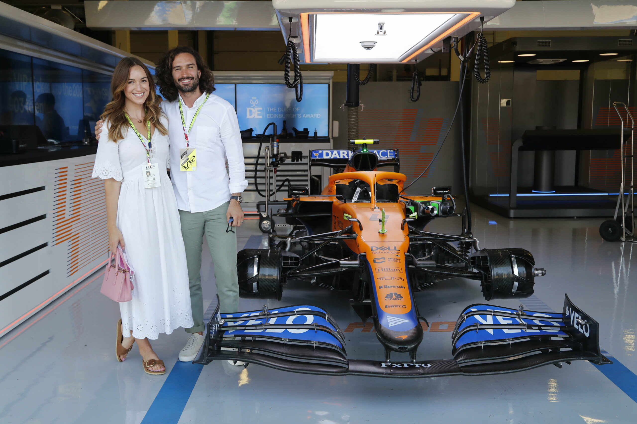 Joe Wicks and his wife smiling at a F1 event
