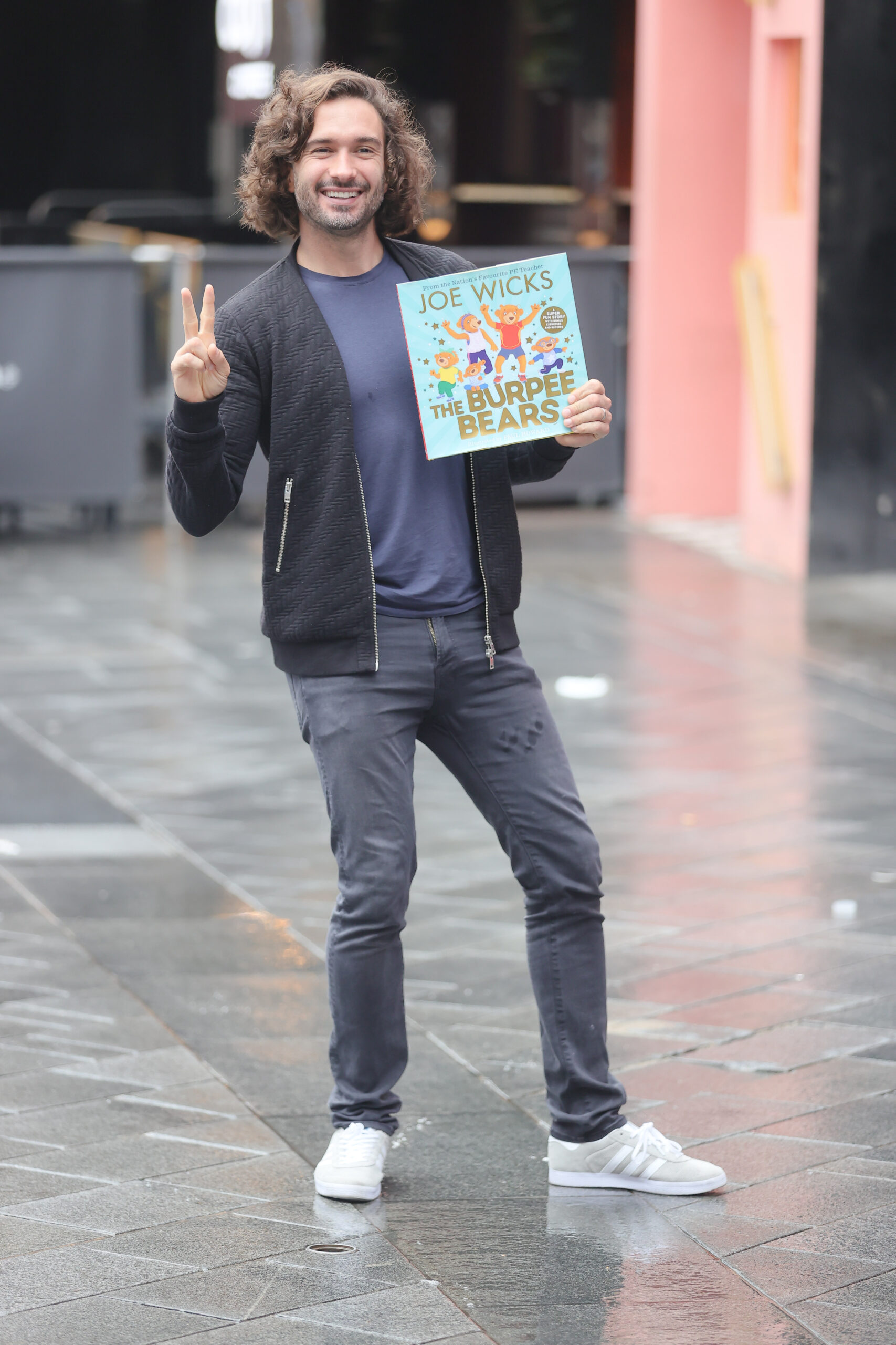 Joe Wicks posing with his book and smiling