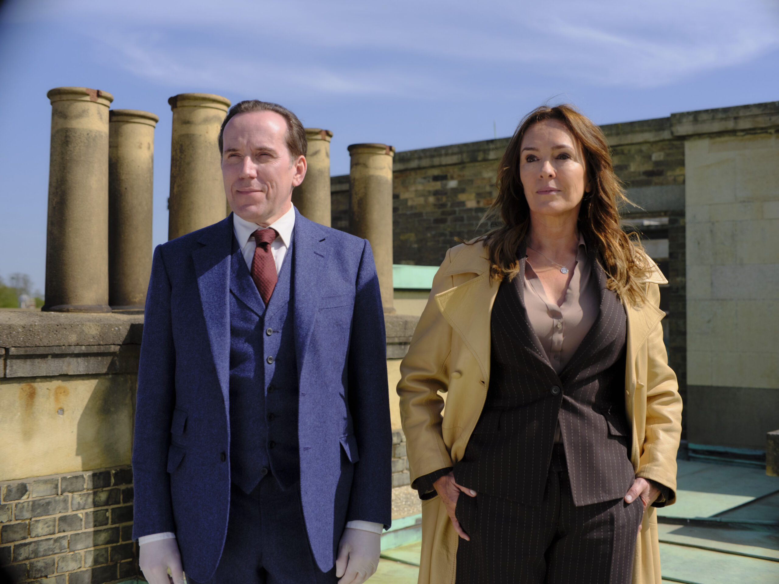 Ben Miller as Professor Jasper Tempest (left) and Juliet Aubrey as Christina Miller, they stand on a roof in suits