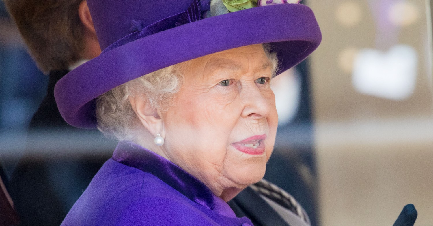 The Queen wearing purple and smiling