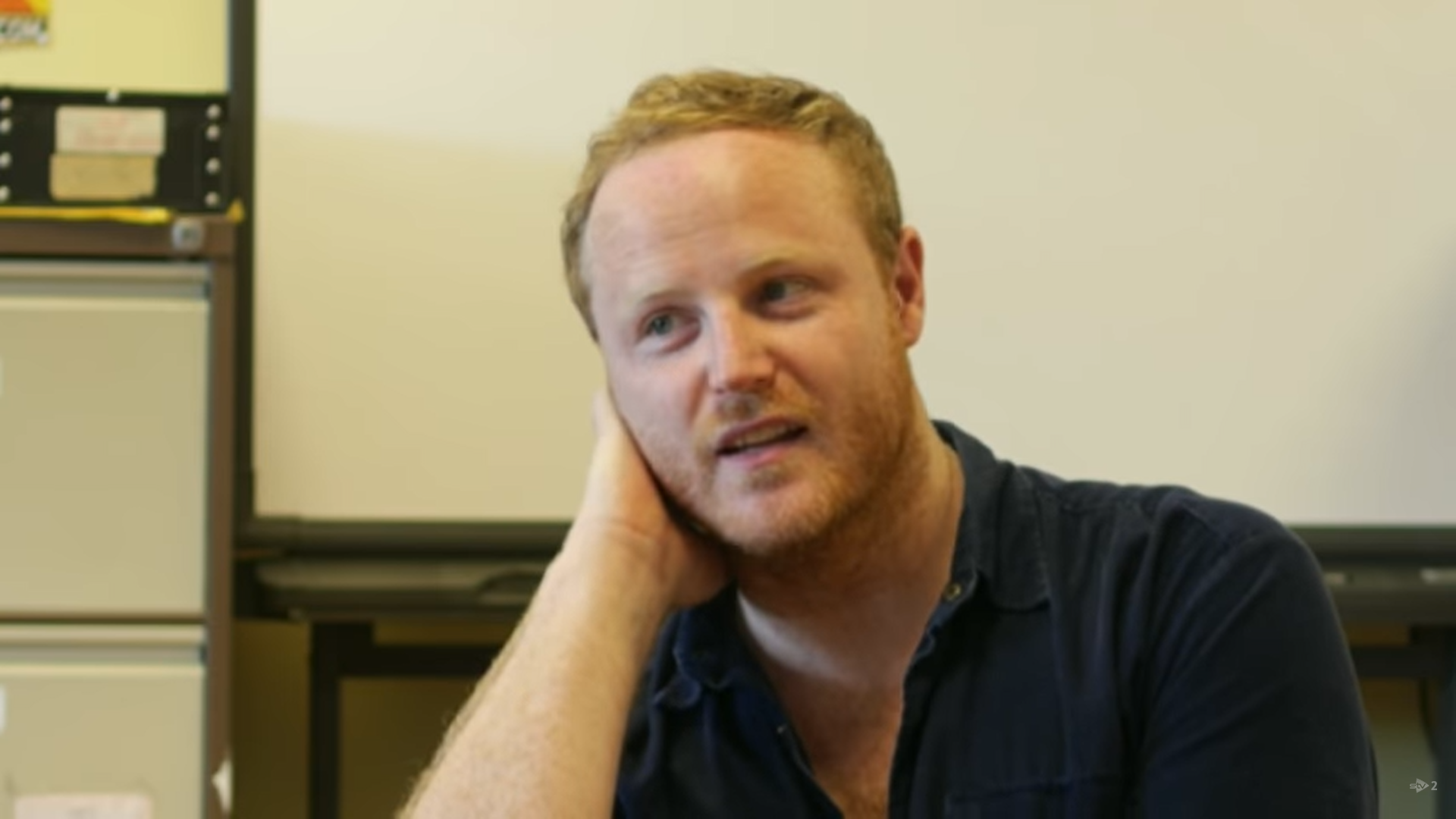 Gary Lamont in an interview, he rests his head on his hand looking off to the right