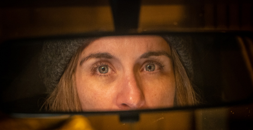 Vicky McClure as Stella Tomlinson, she looks into her car mirror with a sad expression