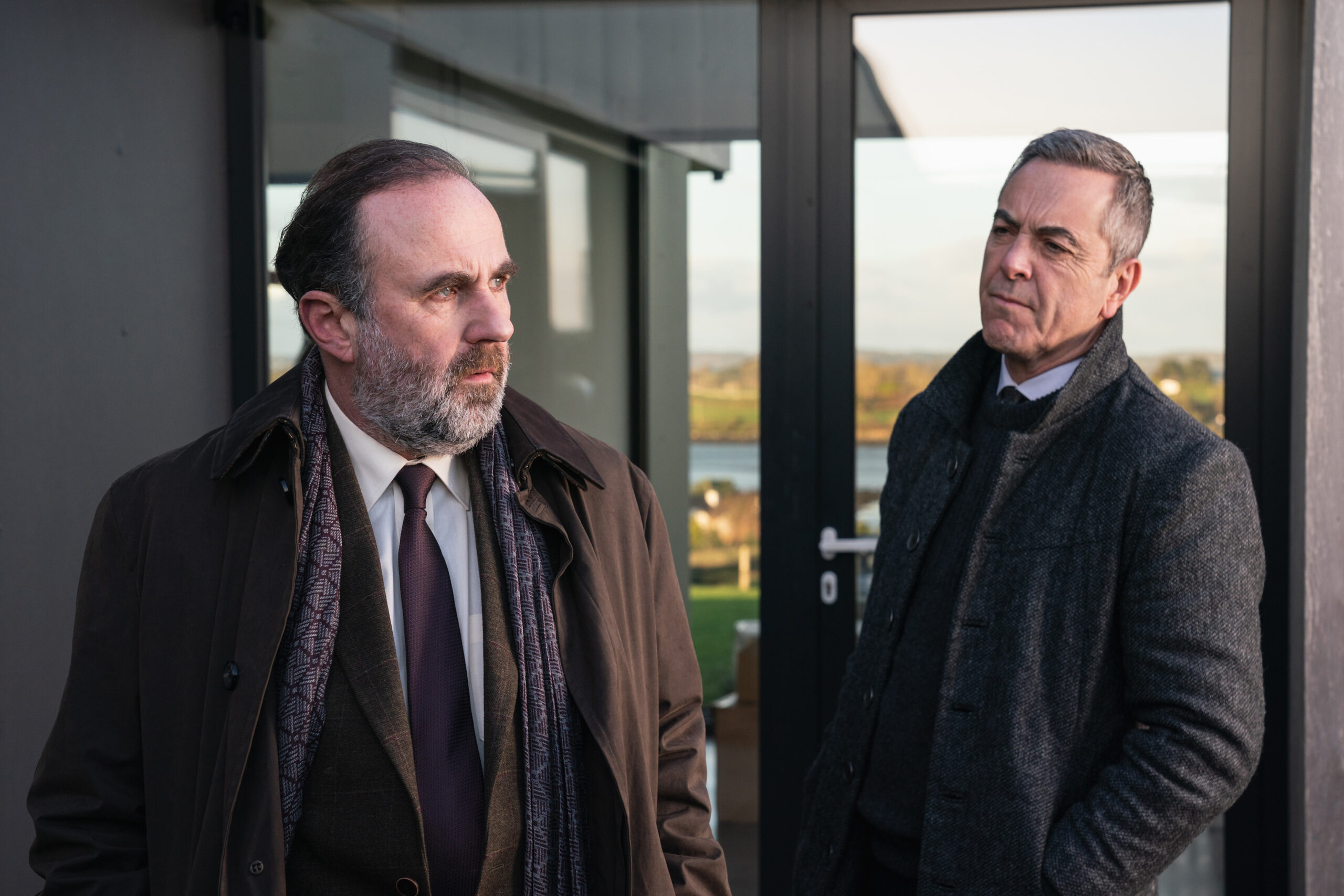 Jackie Twomey (LORCAN CRANITCH), (LEFT) and Tom Brannick (JAMES NESBITT) (right), they stand outside Olivia Foyle's house in suits with worried expressions