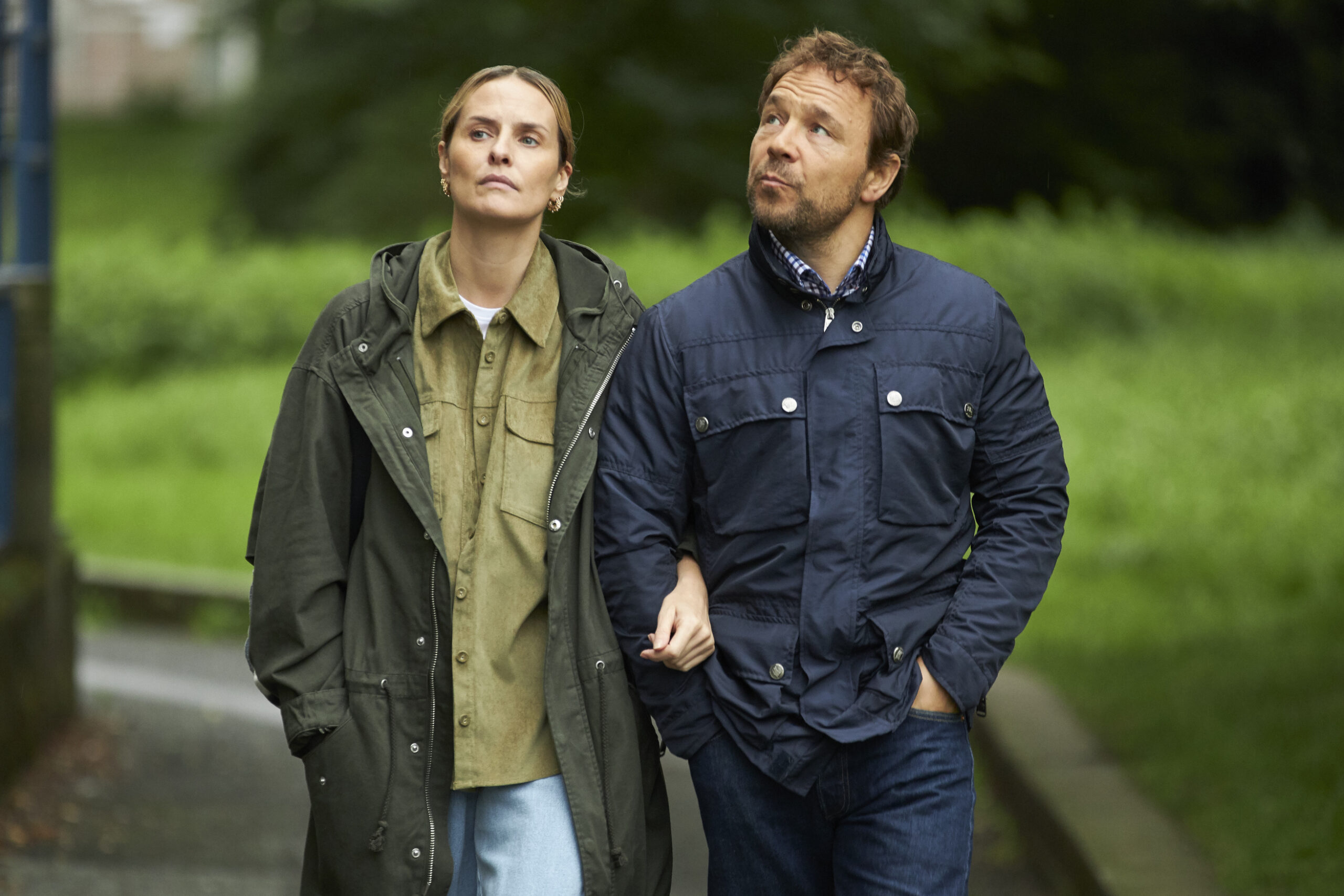 Leanne Best as Allison (left) and Stephen Graham as Matthew (right), they stand arm and arm walking through a park in ITV1's The Walk-In