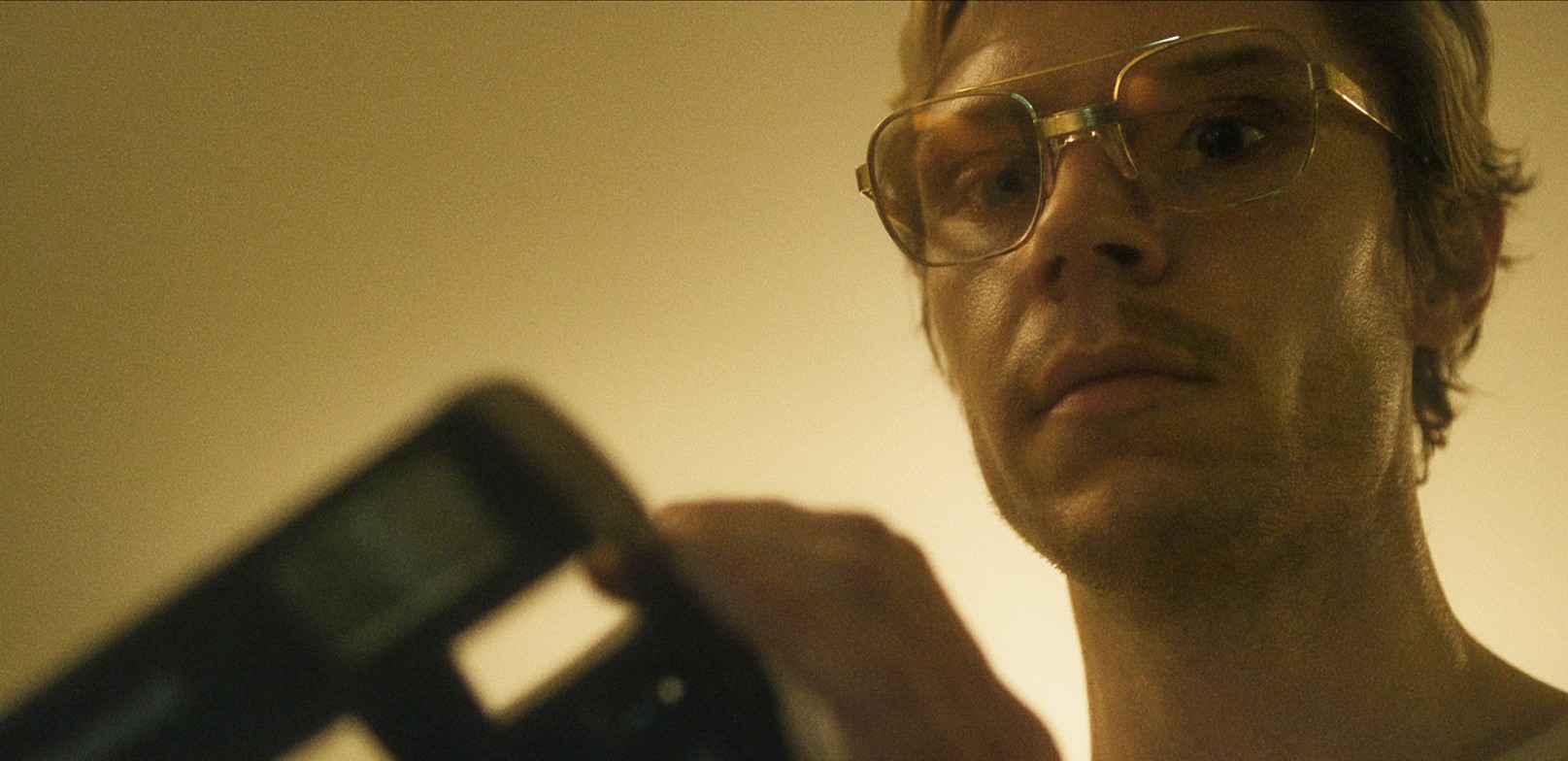 Evan Peters holding a camera in Monster: The Jeffrey Dahmer Story