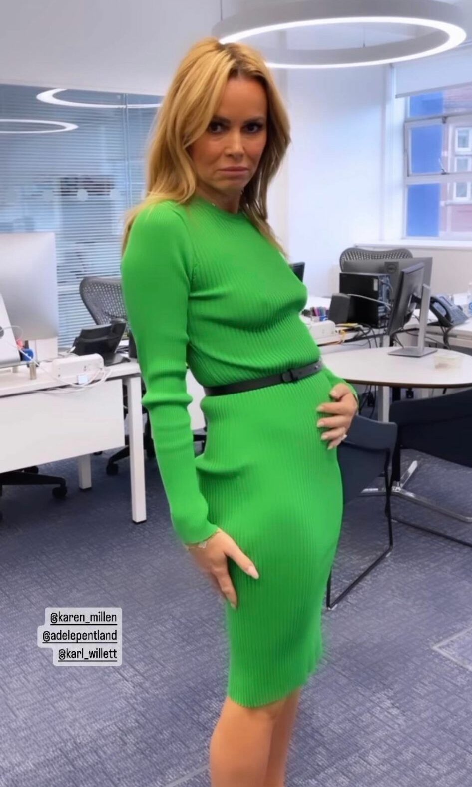 Amanda Holden wearing green dress and cradling tummy