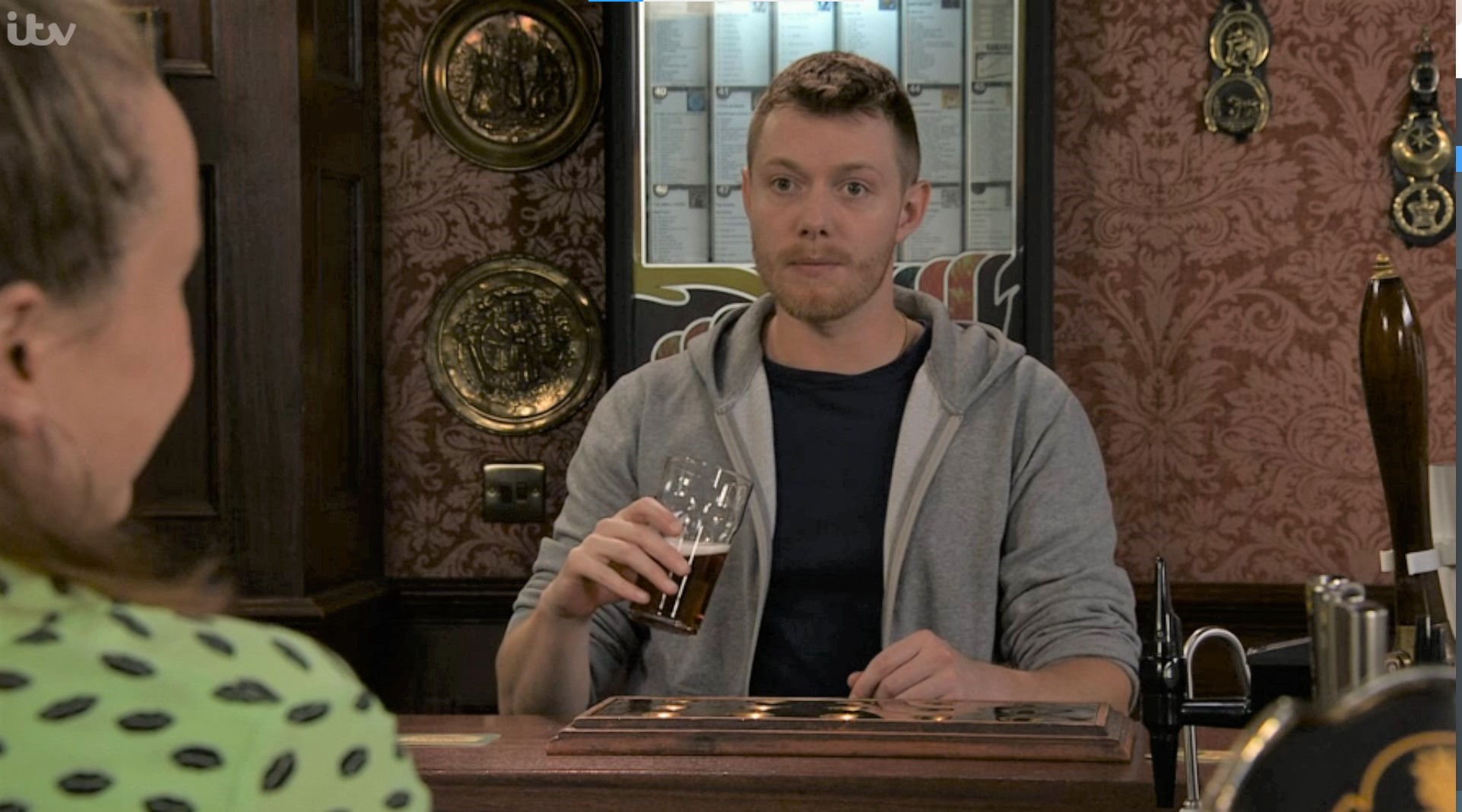 Daniel Coronation Street looks worried as he holds a pint