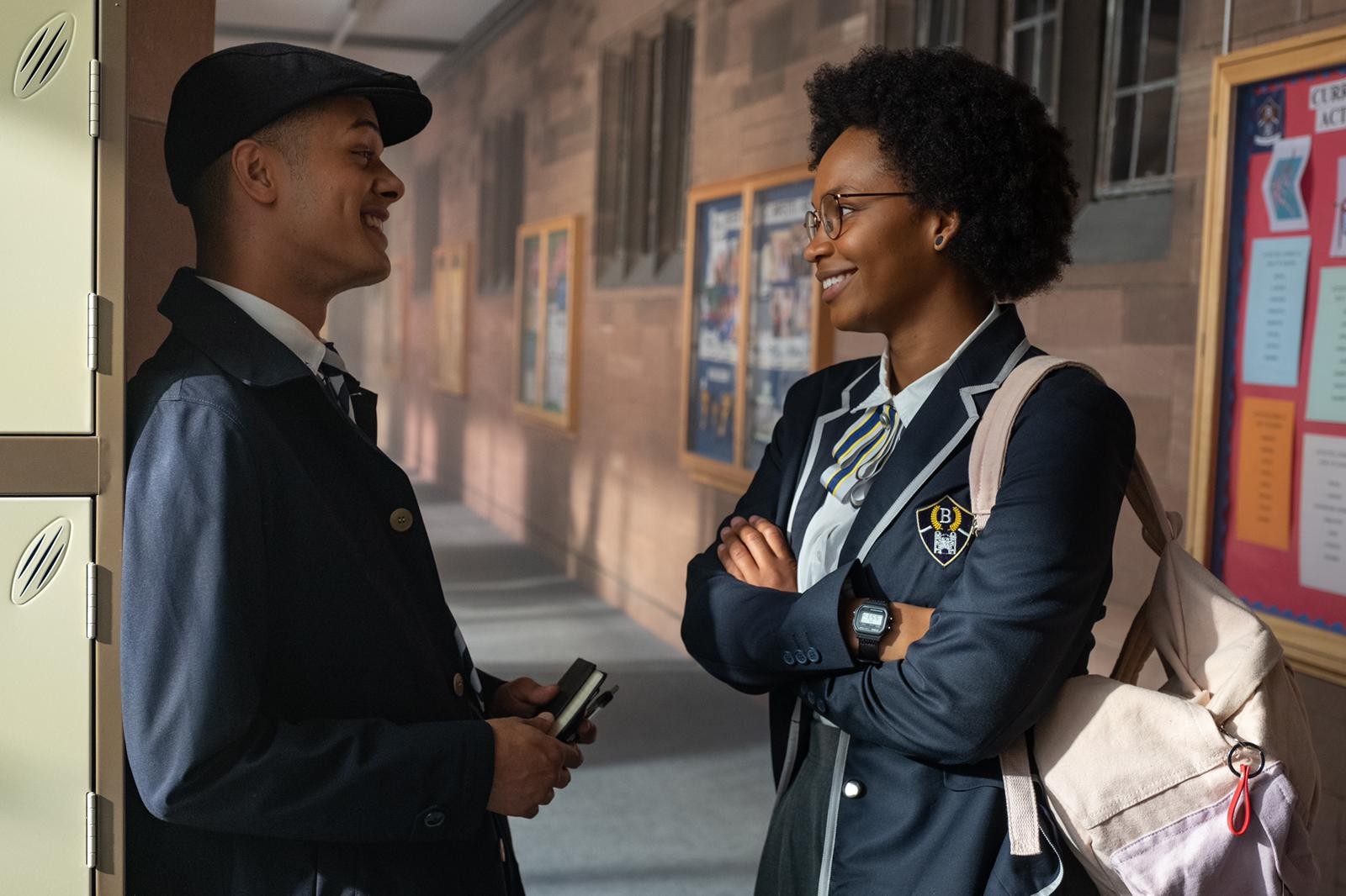 Dylan Brady as Ed in Get Even, he looks at his friend with a smile, wearing a school uniform