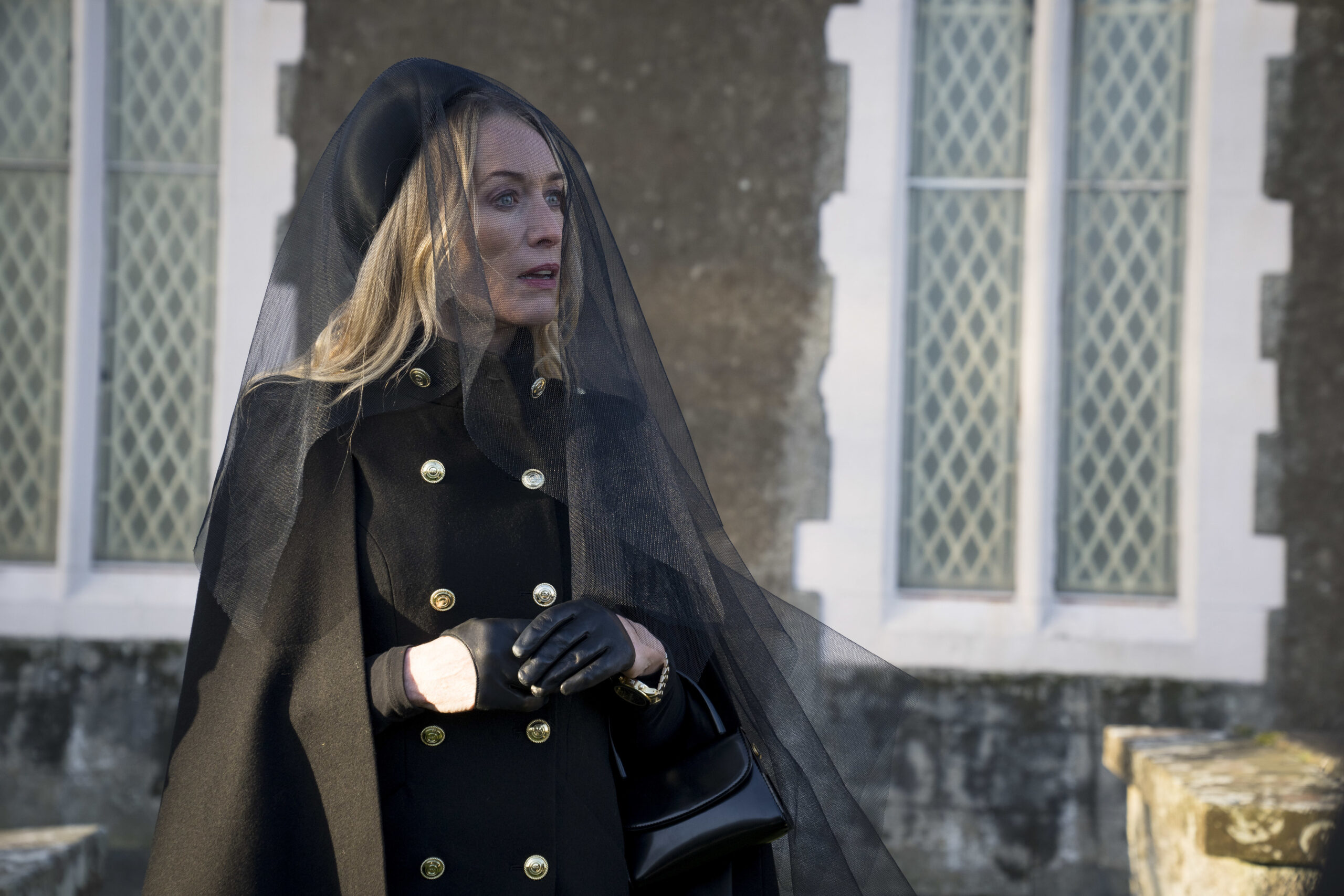 Victoria Smurfit as Olivia Foyle in Bloodlands, she gasps outside a church with a black outfit and black veil over her