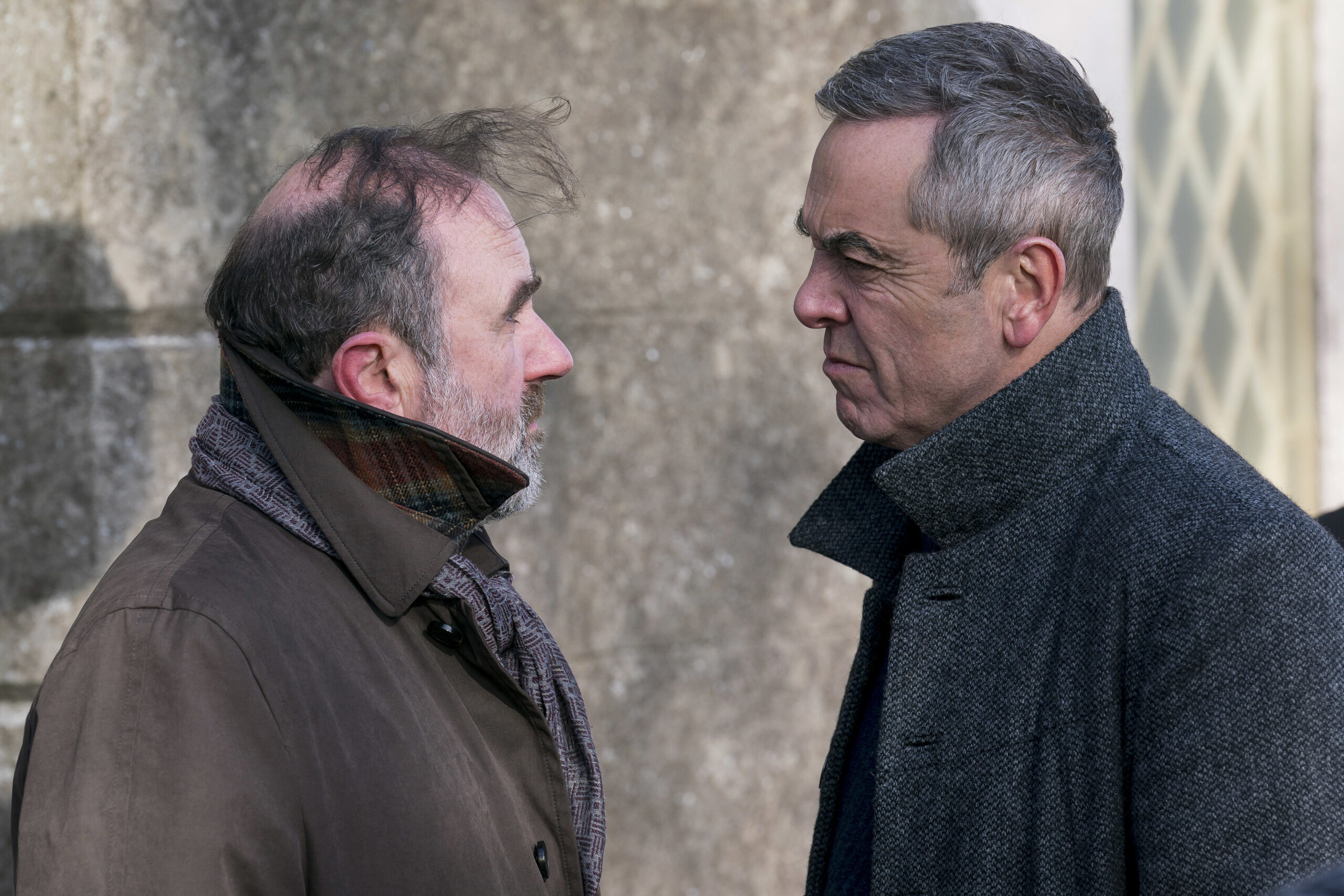 Bloodlands episode 3 Jackie (LORCAN CRANITCH), Tom Brannick (JAMES NESBITT), they face each other with intense expressions outside a church