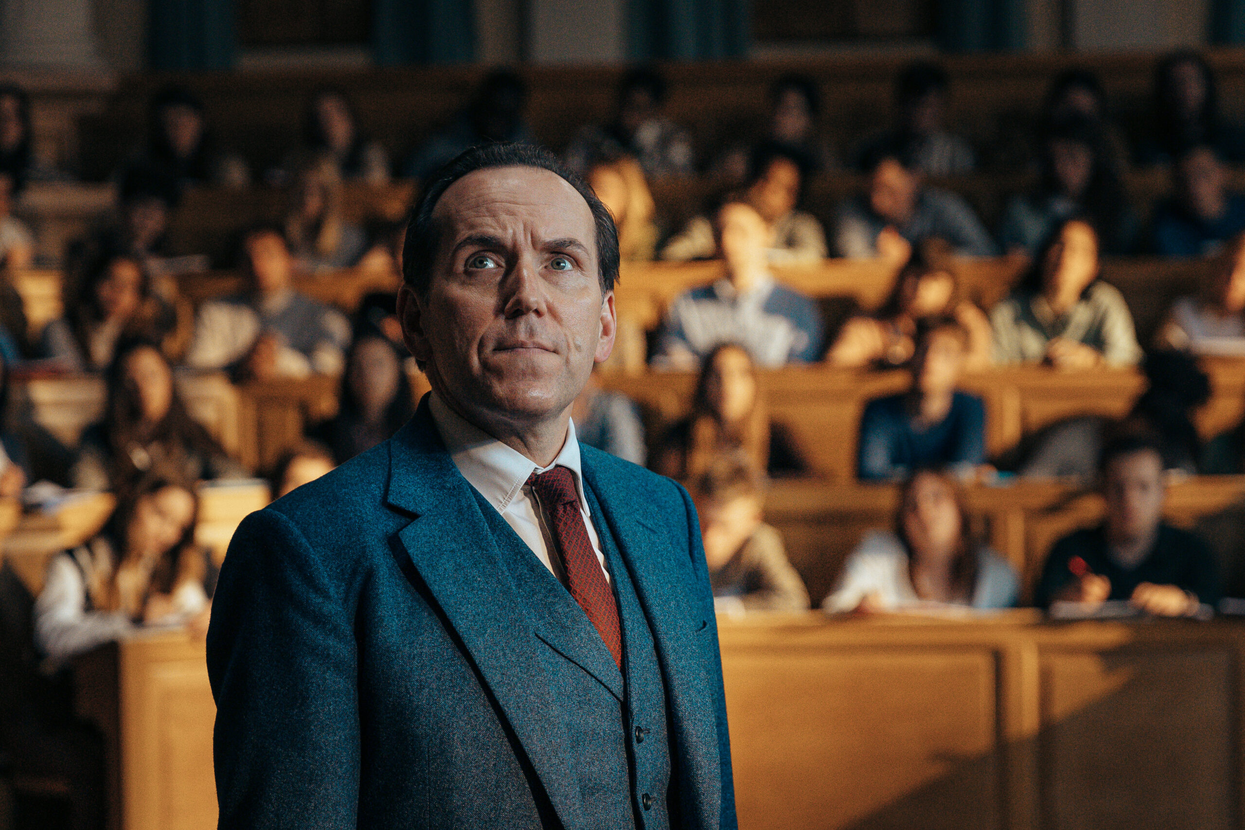Ben Miller as Professor T, he looks up at a chalkboard in front of a lecture