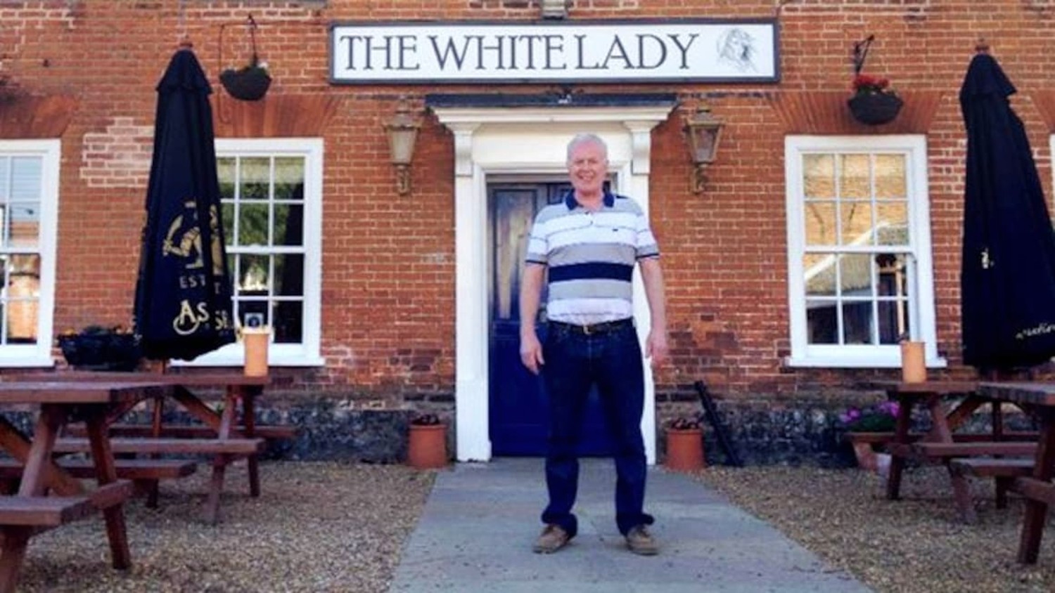 Dennis standing in front of his hotel in Four in a Bed