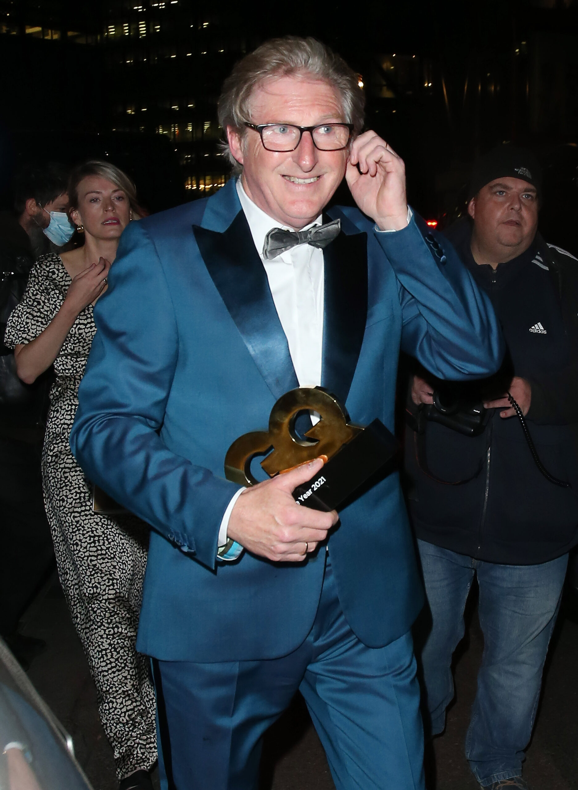 Adrian Dunbar wearing a suit and smiling