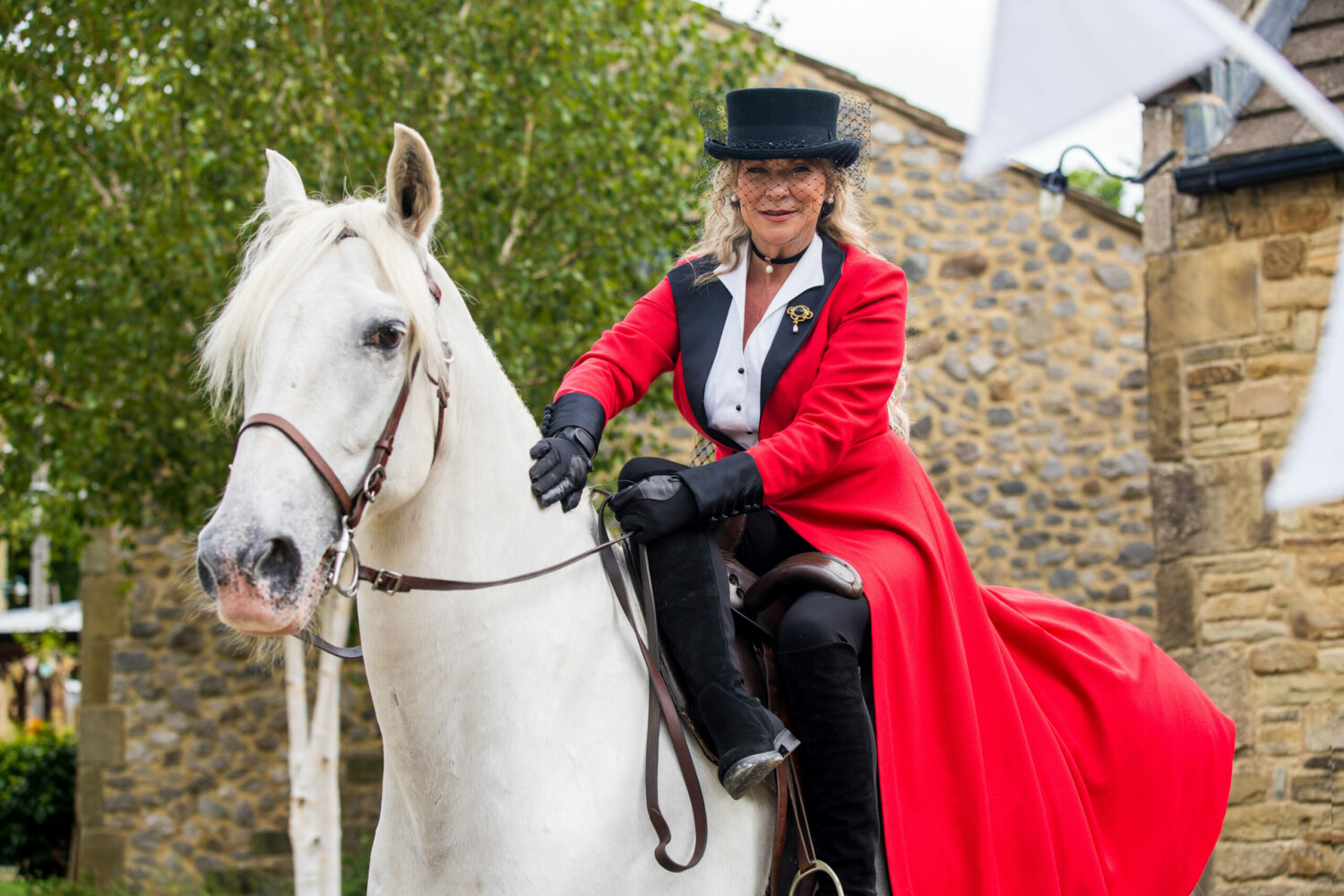 Emmerdale Kim Tate ride her horse to her wedding in red coat and black boots and hat