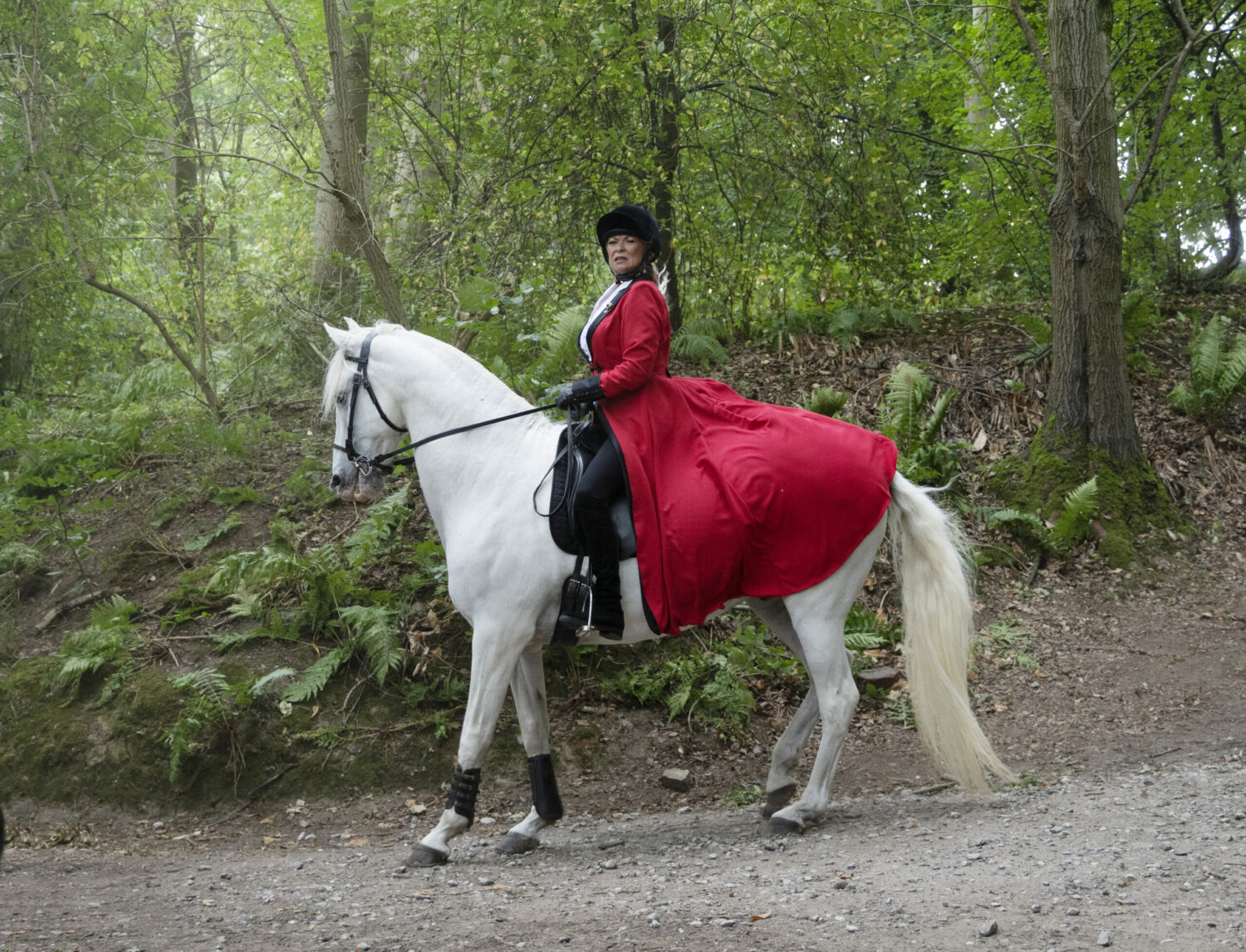 Kim riding a horse through the woods Emmerdale 