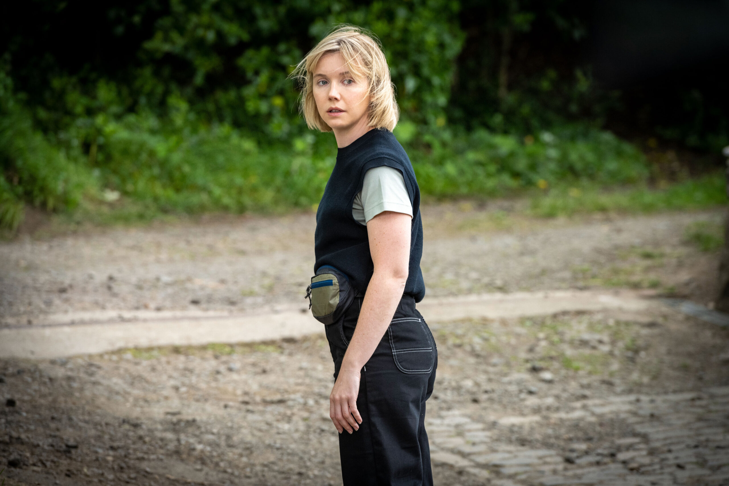 Lauren Lyle as Karen Pirie, she looks off to the side in a road in her police uniform