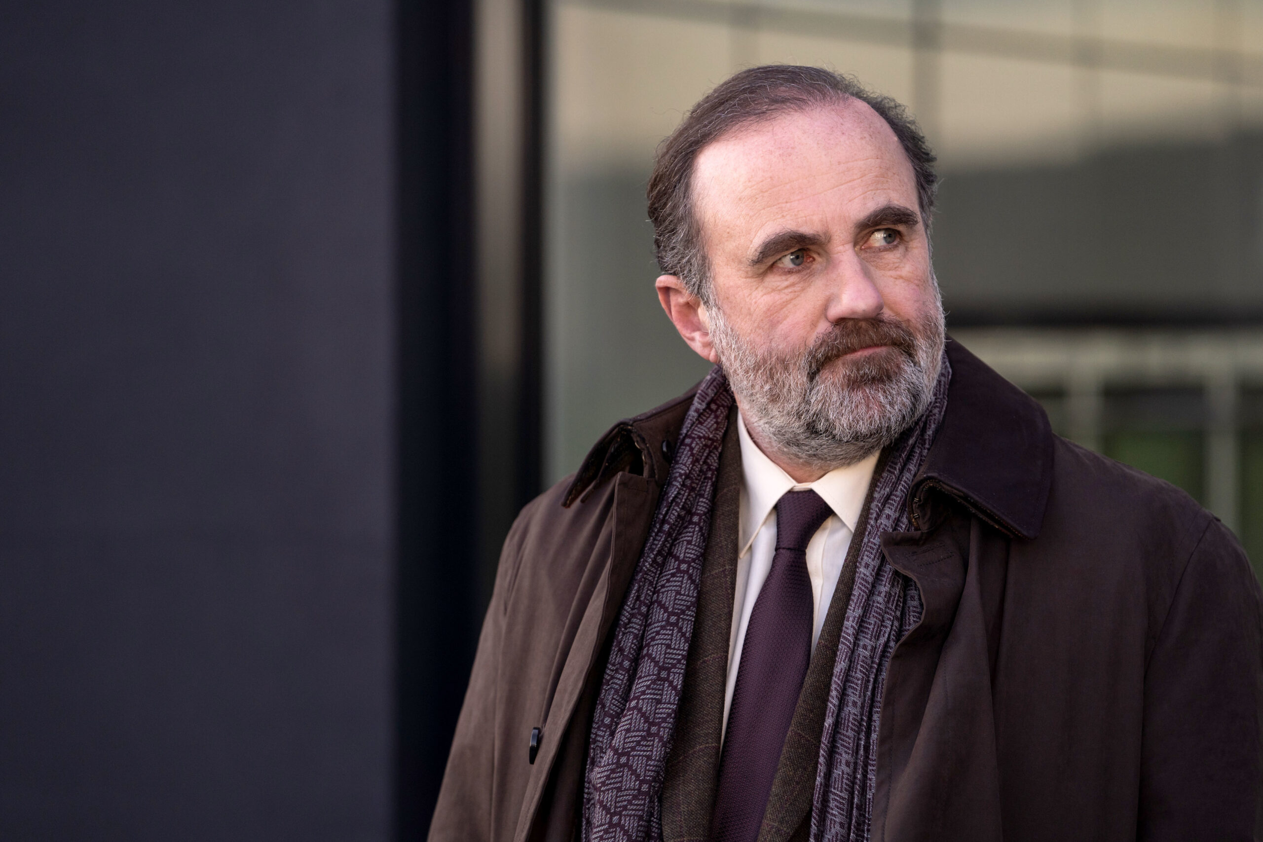 Lorcan Cranitch as Jackie Twomey, he has a small frown as he stands outside Colin Foyle's house