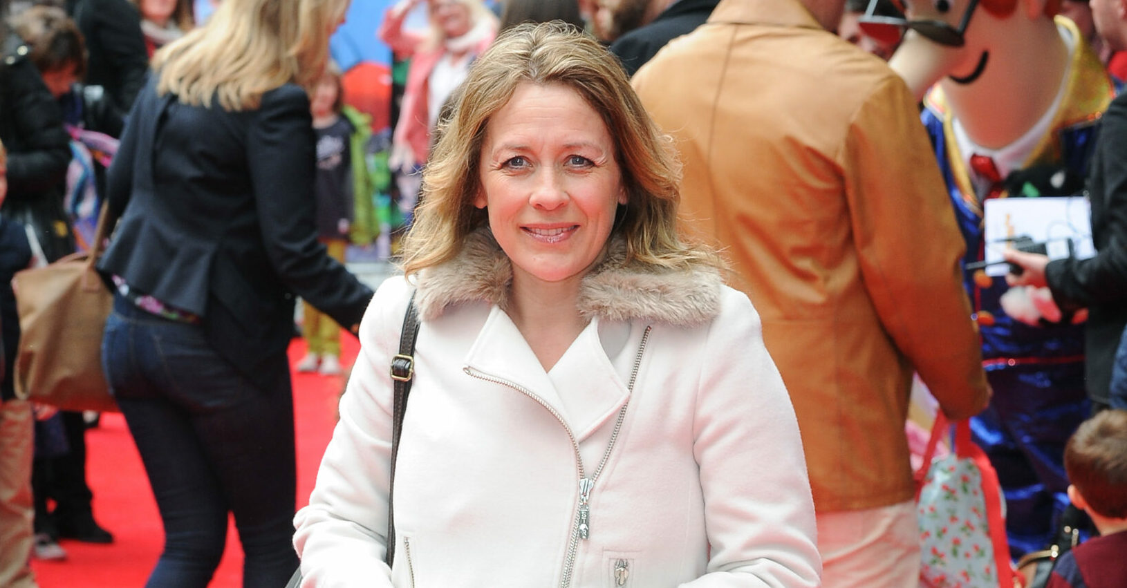 Sarah Beeny on red carpet in a white coat