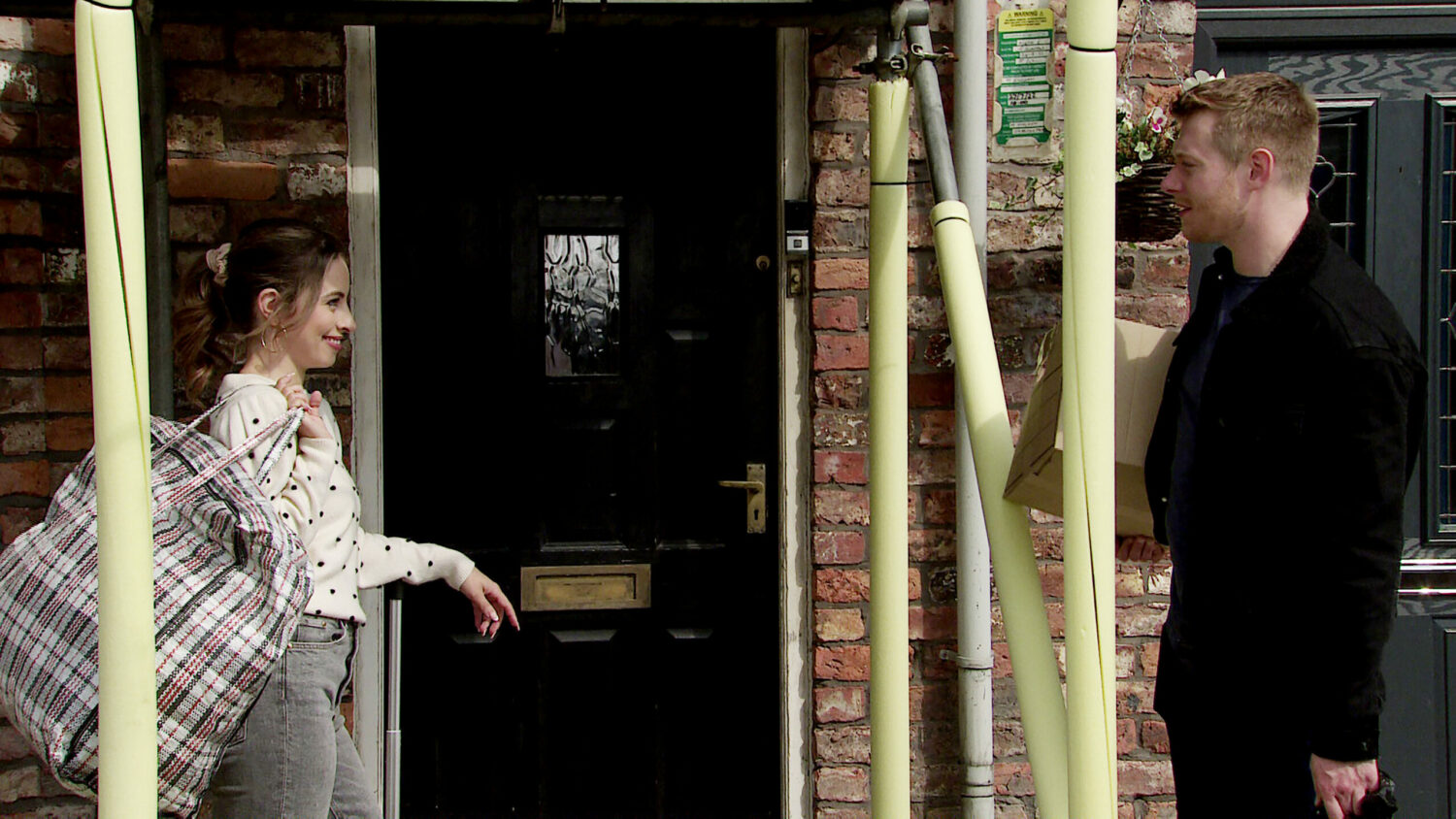 Daniel and Daisy in the street, carrying luggage in Corrie