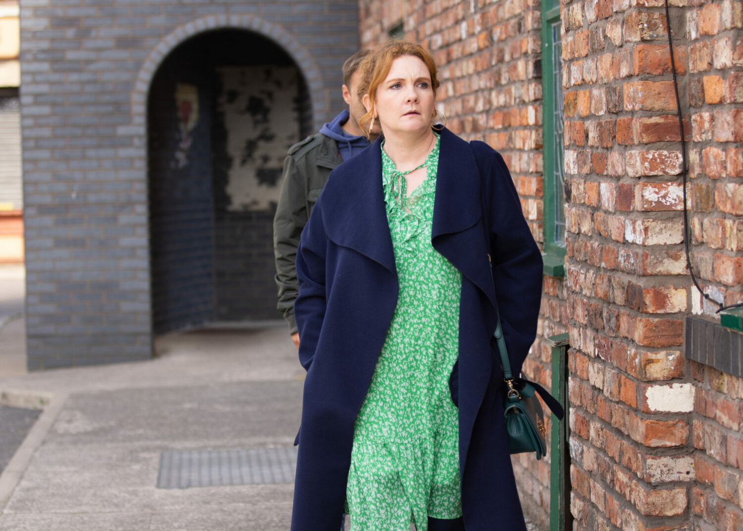 Coronation Street's Fiz wears a green dress and looks worried as she walks away from Tyrone