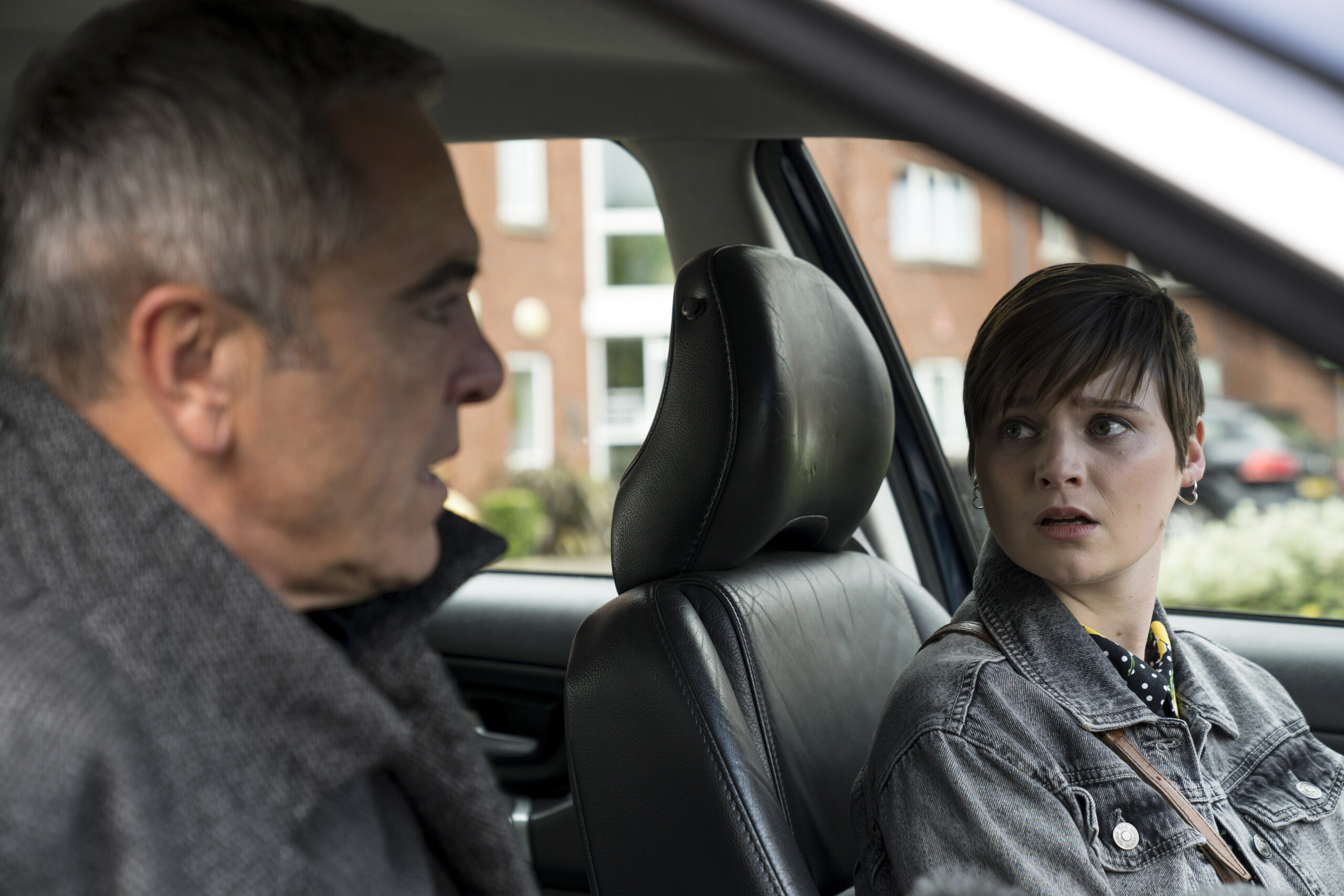 Lola Petticrew as Izzy Brannick (right) she looks over at James Nesbitt as Tom Brannick in the car, they both have sad and worried expressions