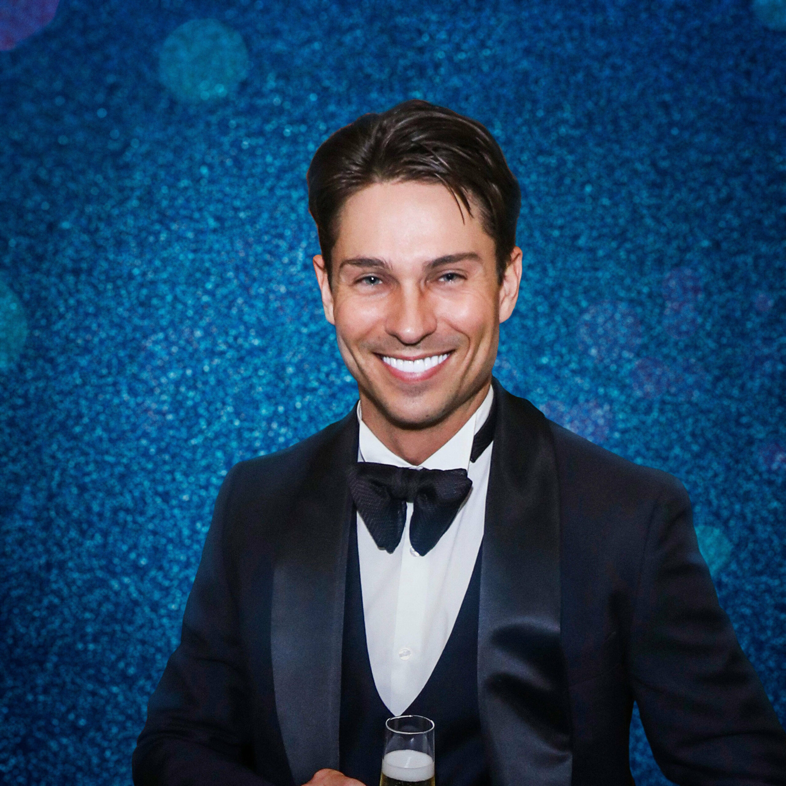 Joey Essex standing in front of blue glitter boarding for Dancing On Ice