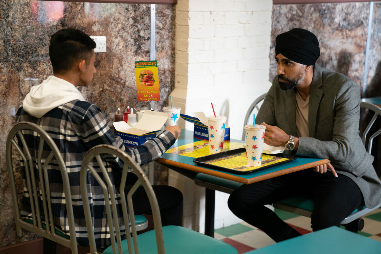 EastEnders Nugget and Kheerat speaking at the table