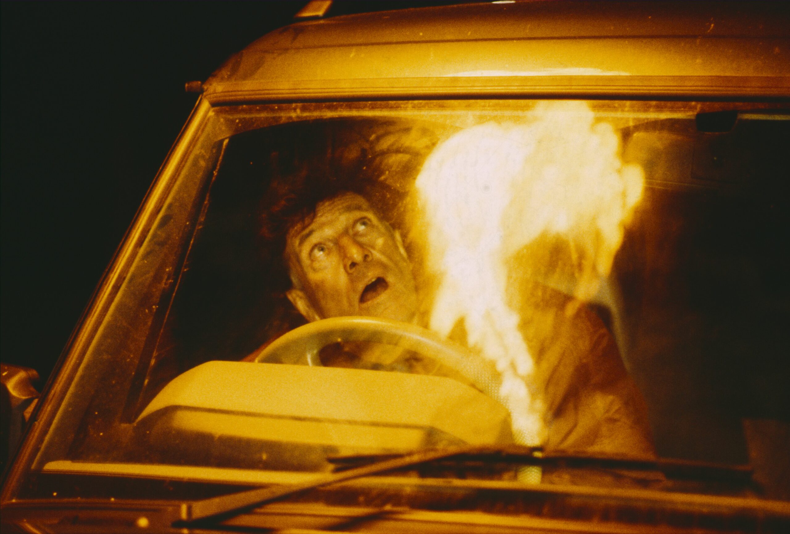 Emmerdale Frank Tate looks shocked as a plane crash then explodes into a fireball while he's driving 