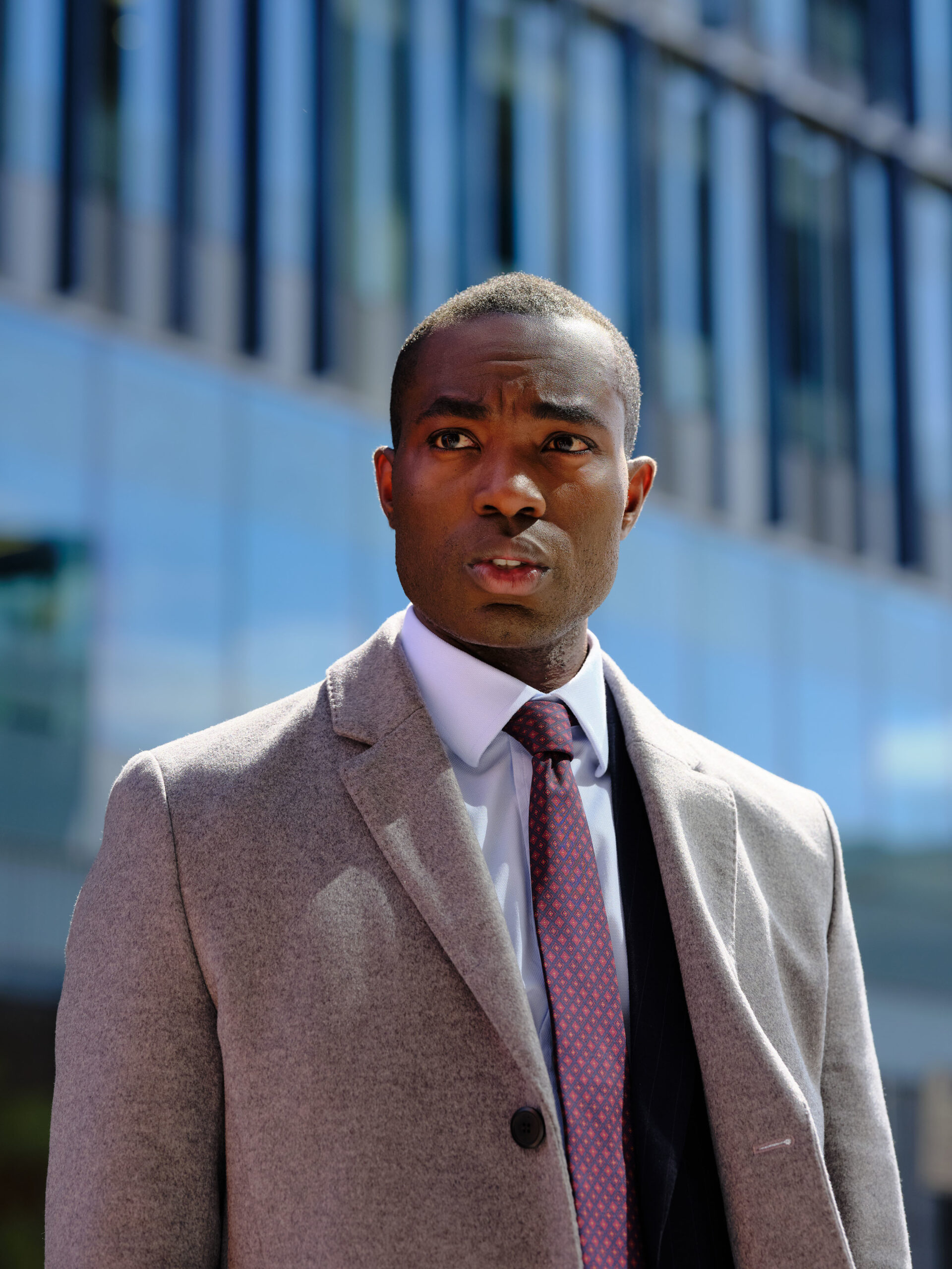 Paapa Essiedu as Isaac Turner in The Capture, he looks up to the left outside a large building