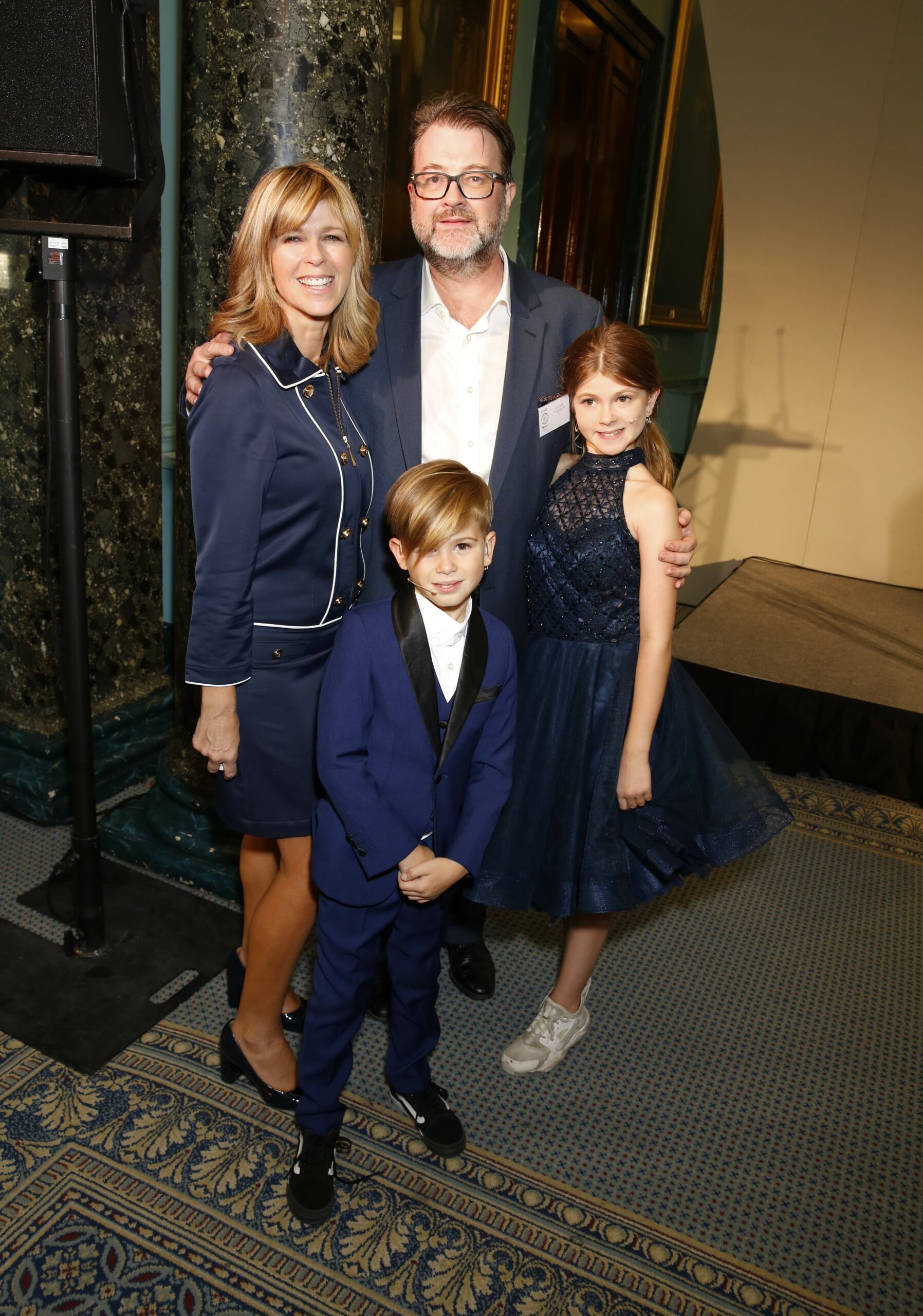 Kate Garraway smiling with husband Derek and their children at event