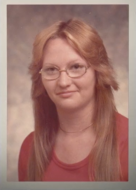 Sheryl Kellison poses for a photo, she has is young and has glasses on