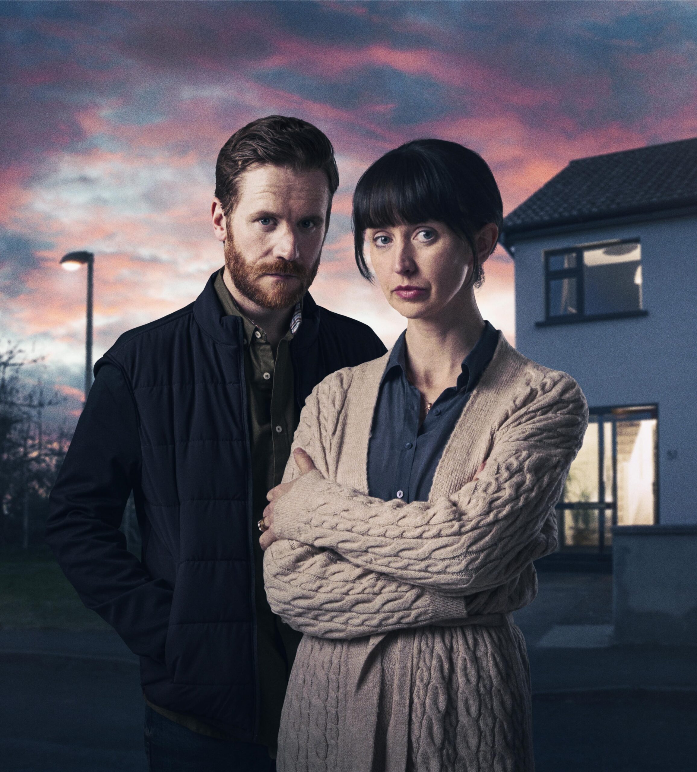 OWEN (IAN-LLOYD ANDERSON) and SABINE (LISA DWYER HOGG) in The House Across The Street, they stand close outside their home with worried expressions