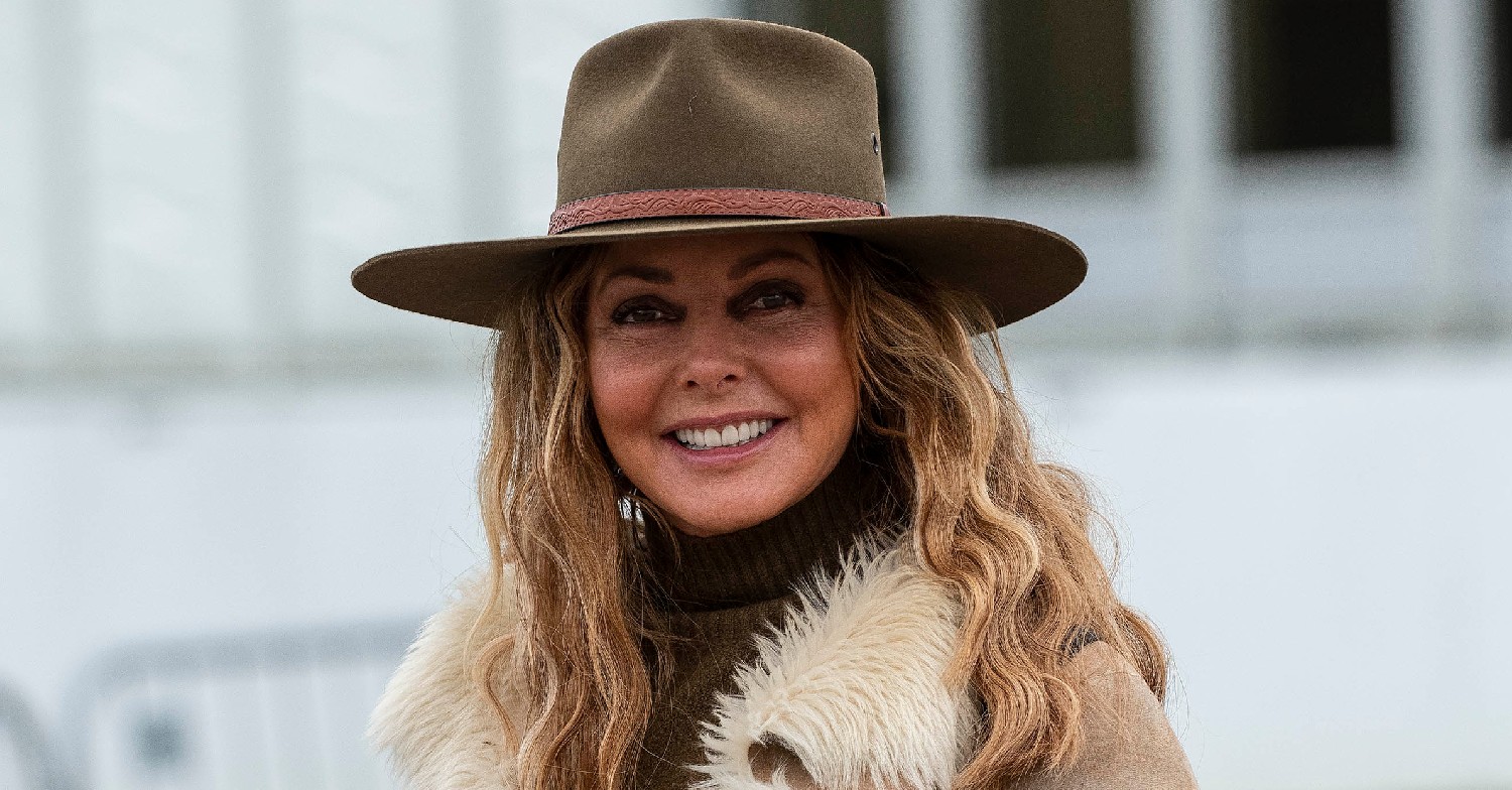 Carol Vorderman smiling with a hat on at horse races