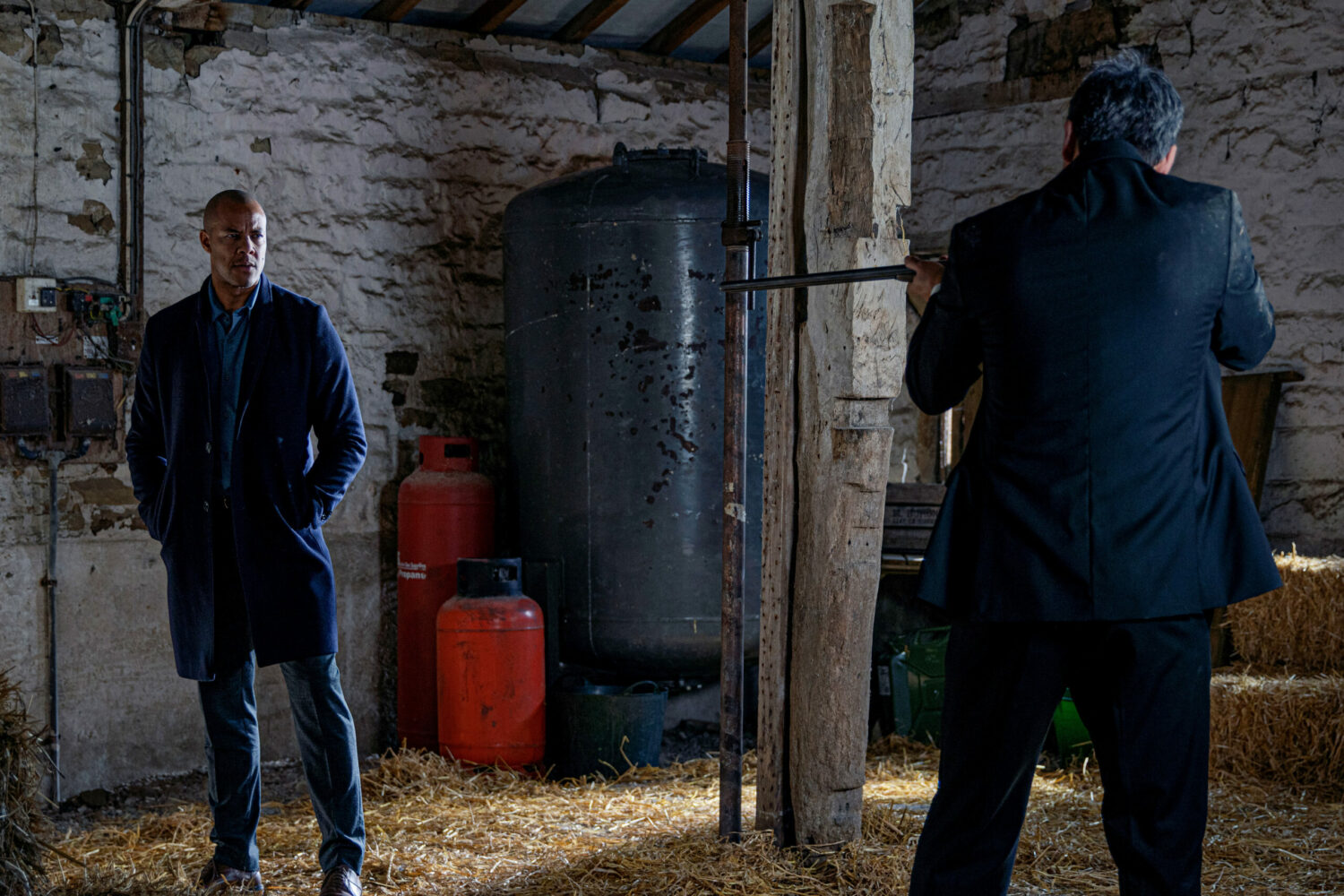 Emmerdale's Cain pointing a shotgun at Al in a barn
