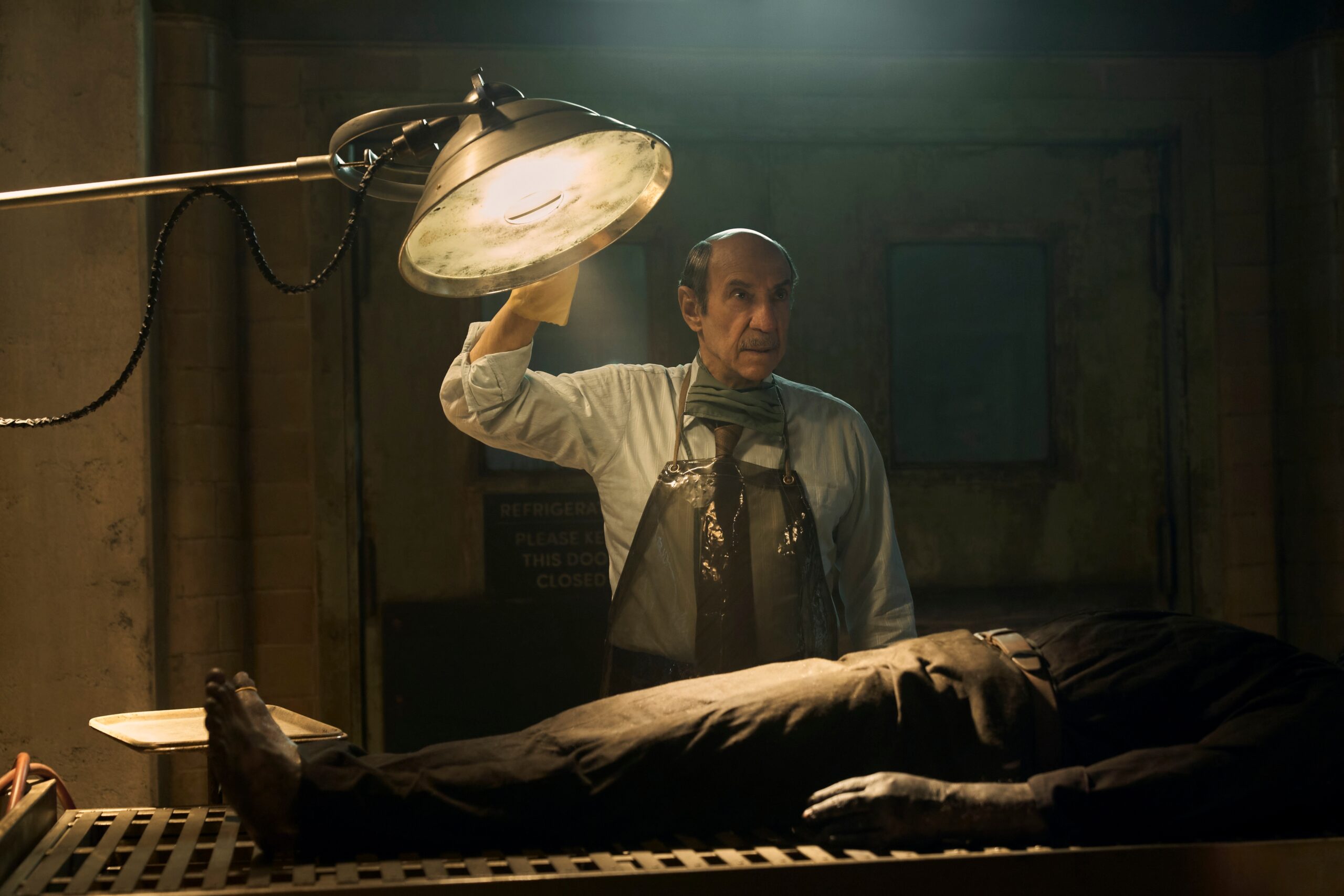 F Murray Abraham stands at an autopsy table with a corpse