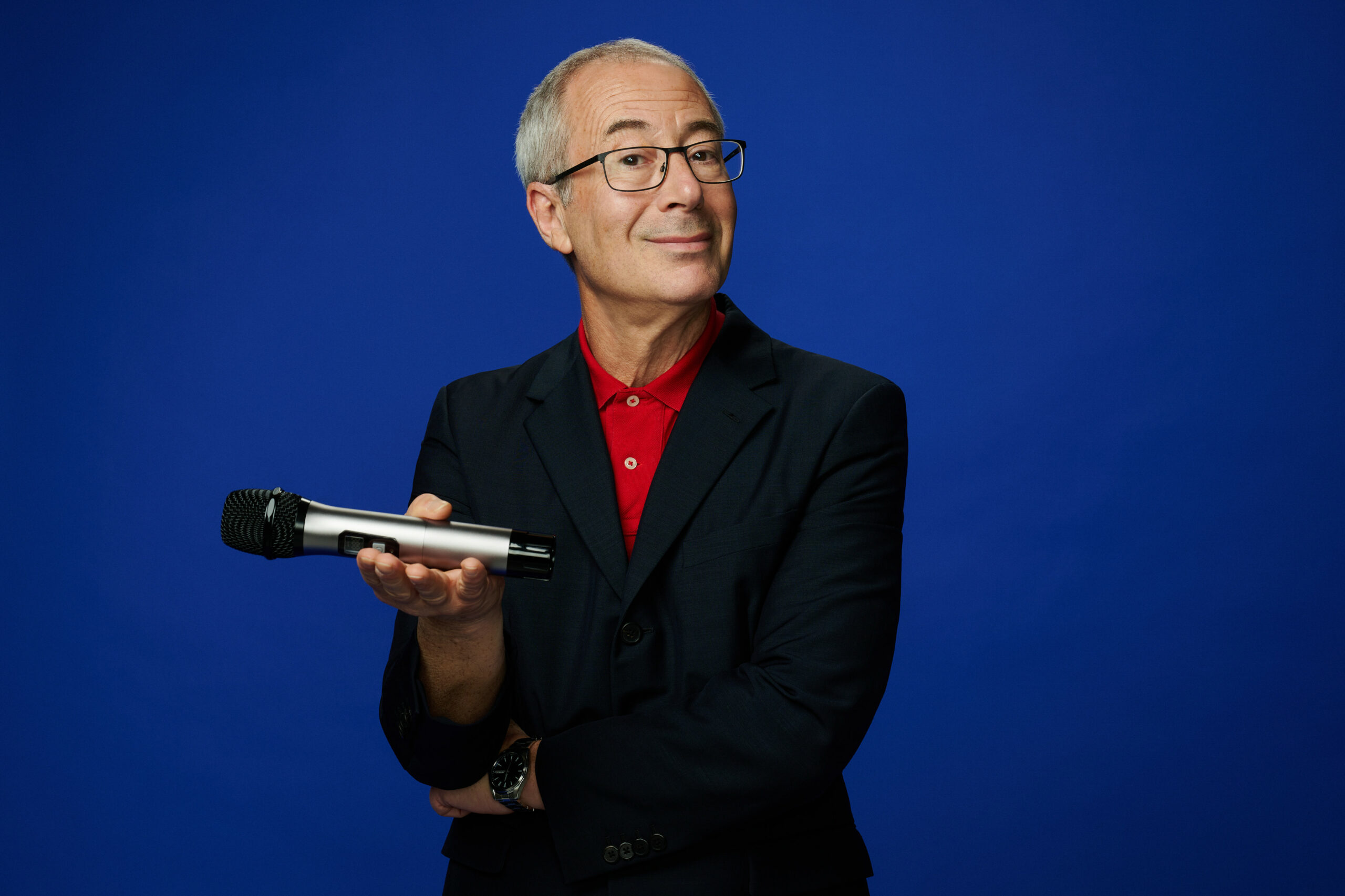 Ben Elton holding a mircrophone in Friday Night Live