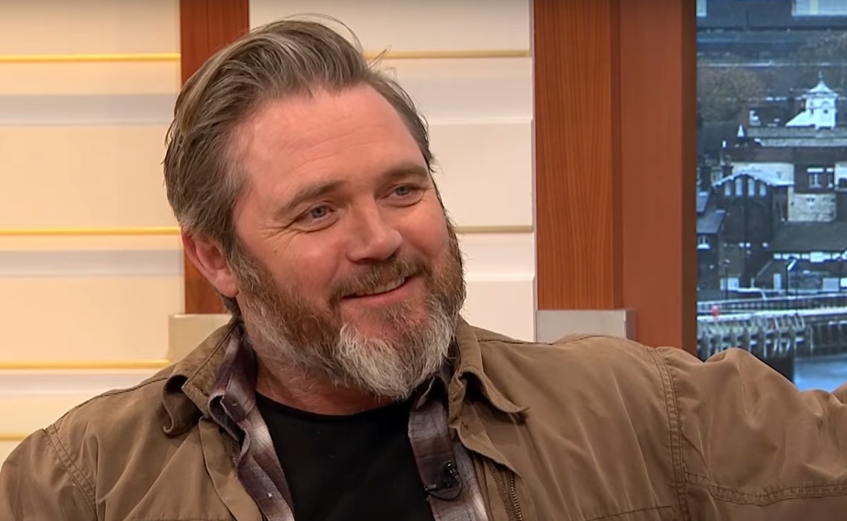 The Devil's Hour's Alex Ferns smiling in an interview