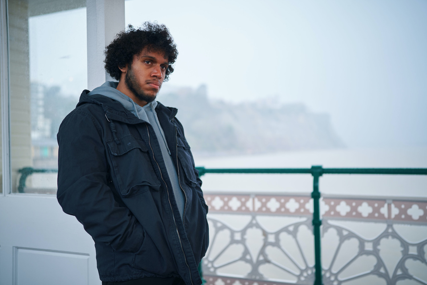 The Pact's Connor (Jordan Wilks) standing on Penarth Pier looking sad