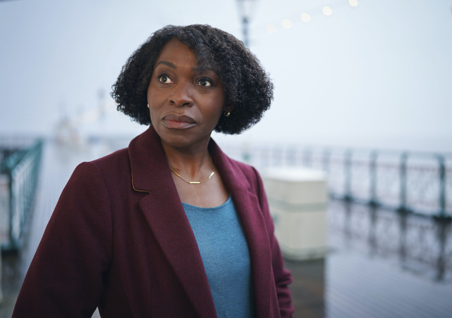 Christine (Rakie Ayola) in The Pact standing on Penarth Pier looking pensive 