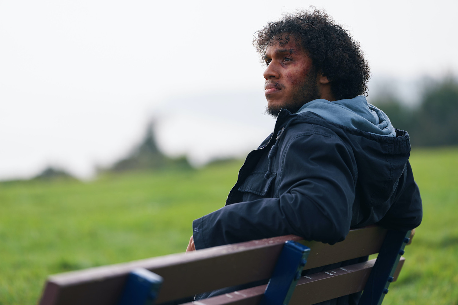 Jordan Wilks in character as Connor sitting on a park bench