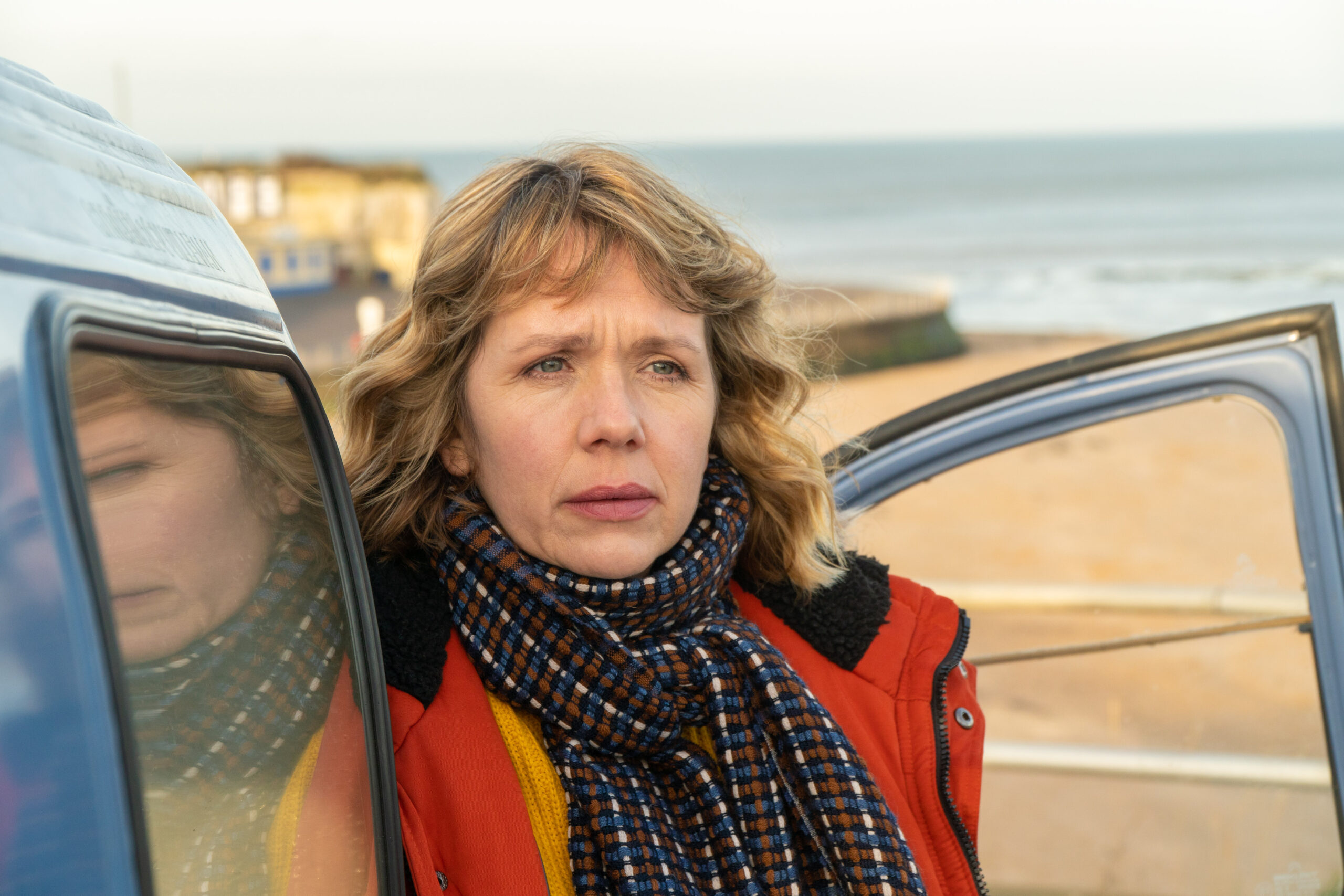Kerry Godliman as Pearl Nolan, she looks out on a beach from her car with a frown