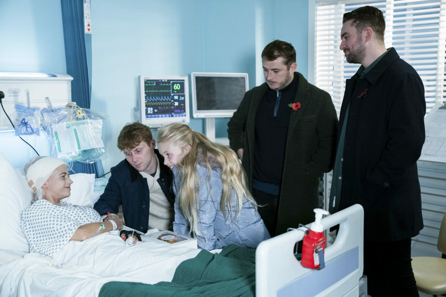 EastEnders Lola in hospital, surrounded by Jay, Lexi, Ben and Callum
