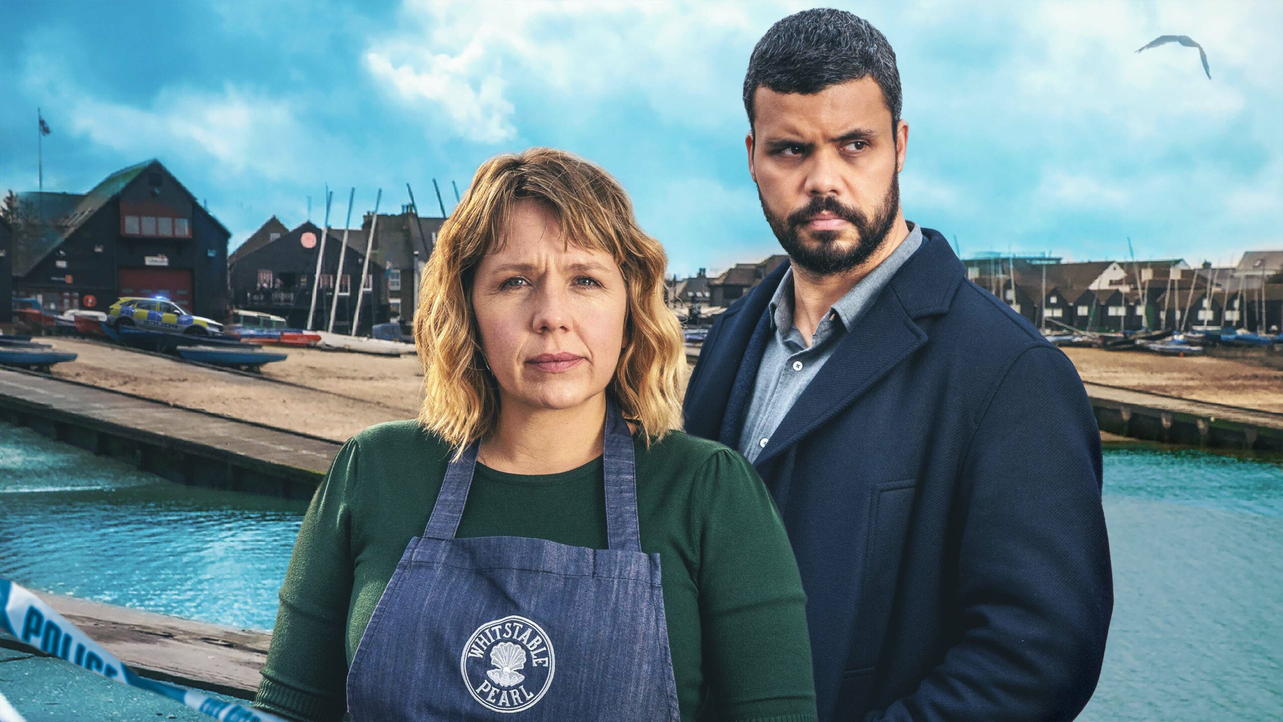 Kerry Godliman as Pearl (left) and Howard Charles as Mike (right) they look out with neutral facial expressions with the backdrop of Whitstable behind them