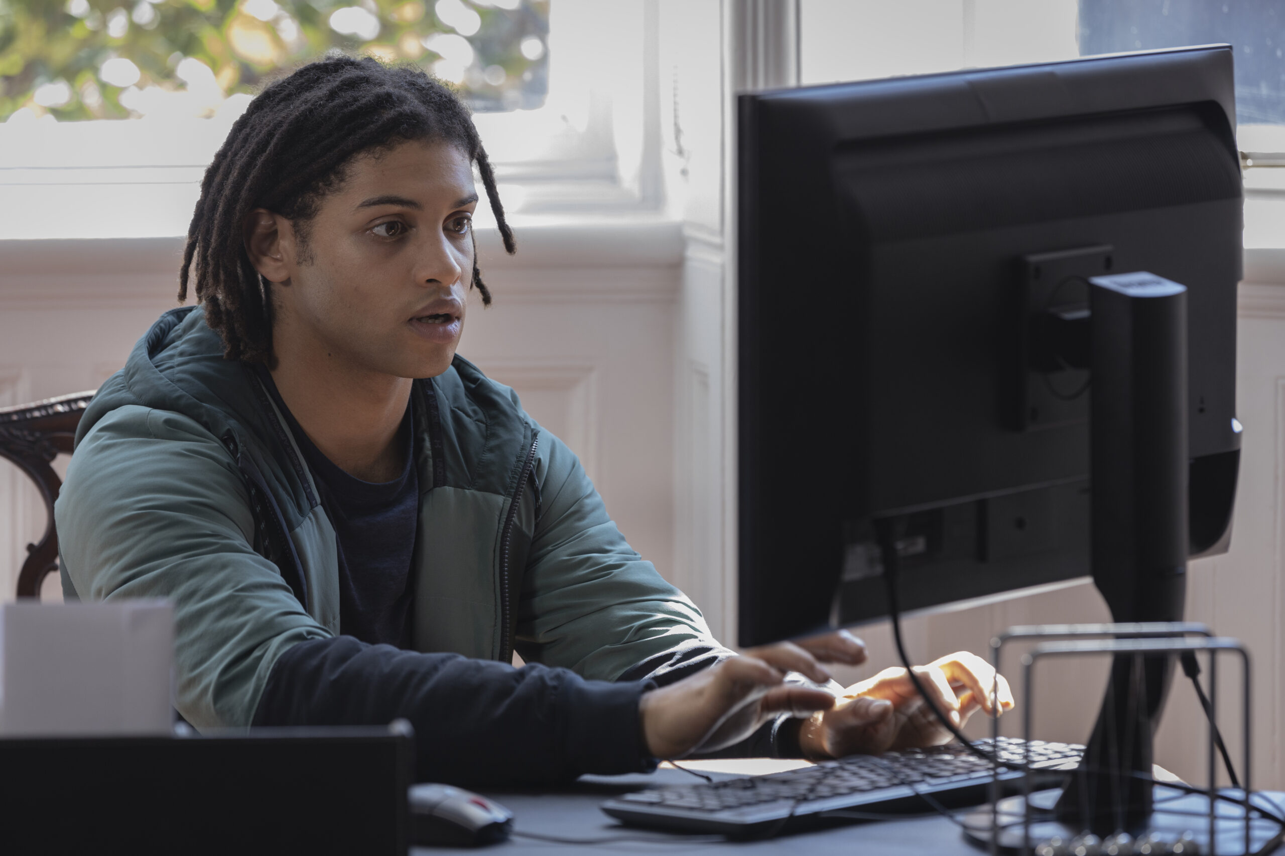 Fergus types on a computer in Harry Wild