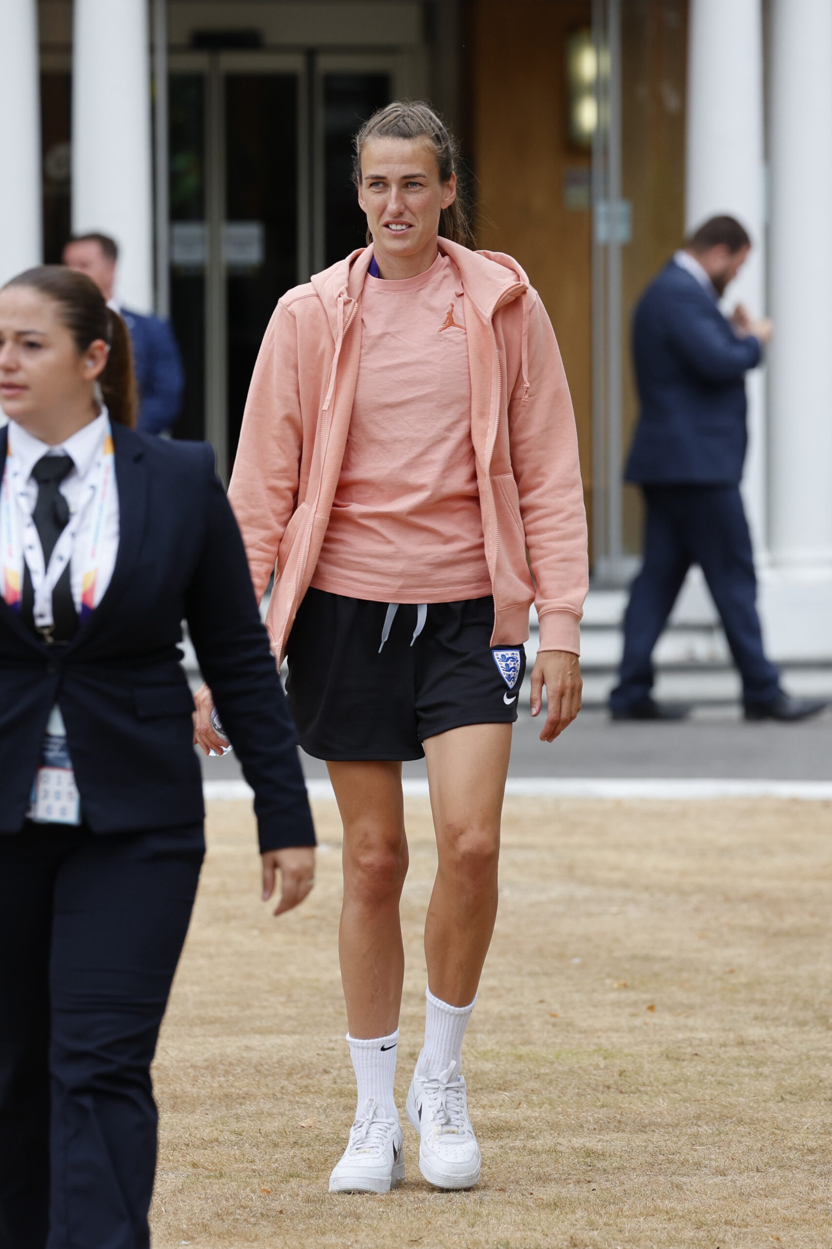 Jill Scott wearing a peach top and hoodie