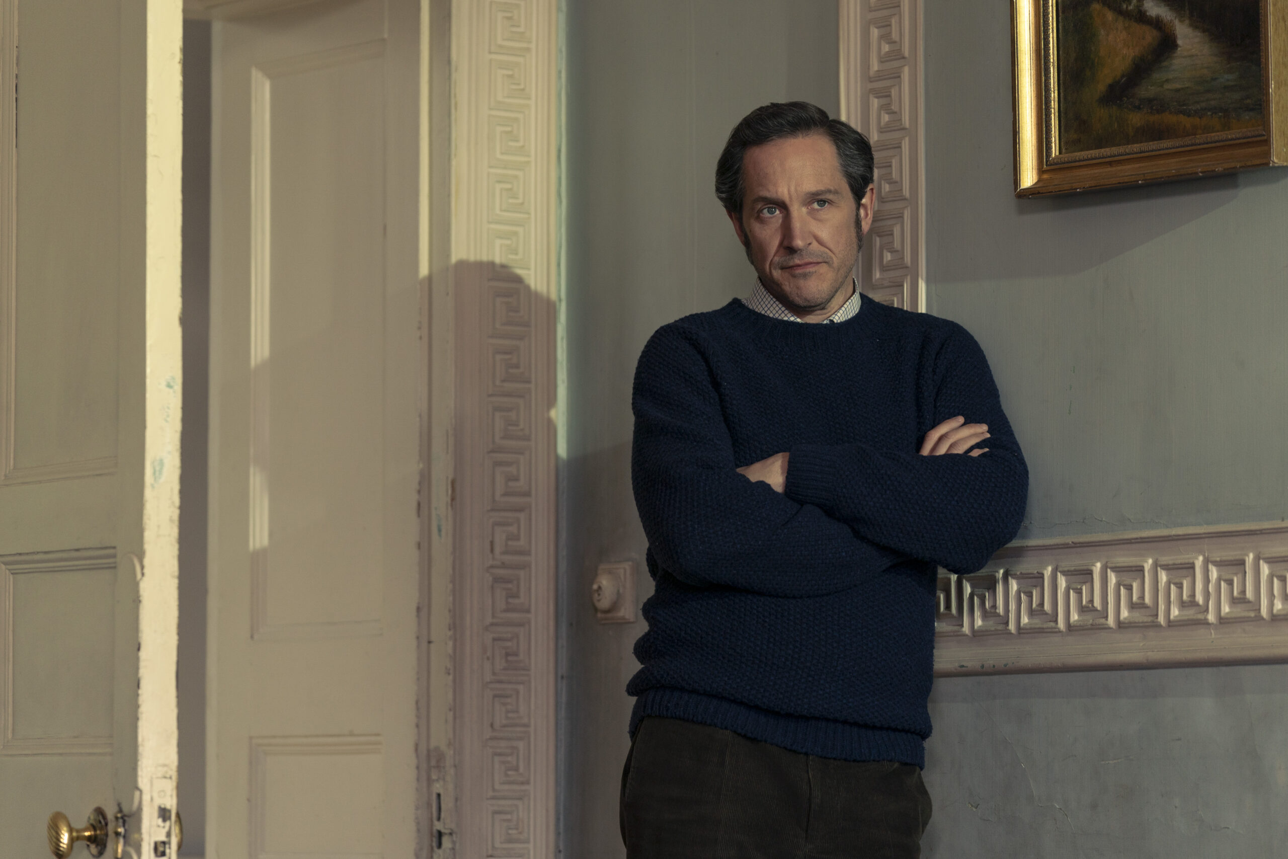 Dalgliesh crosses his arms with a smirk