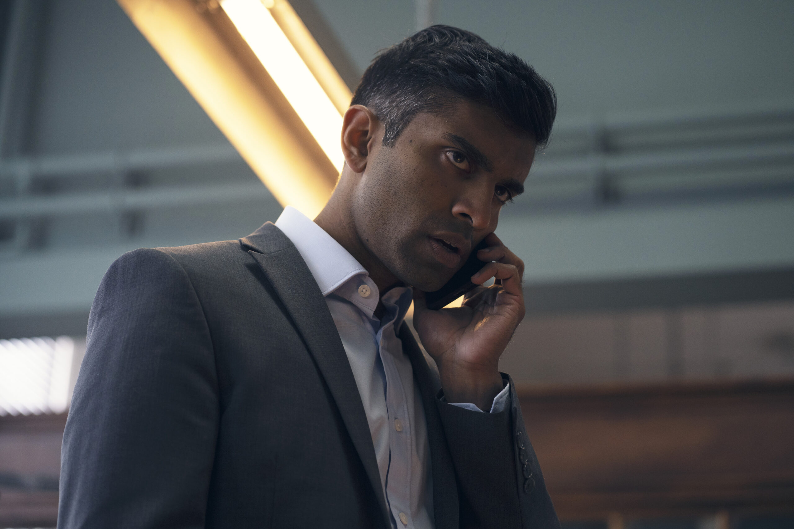 DI Ravi holds his phone with a stressed expression