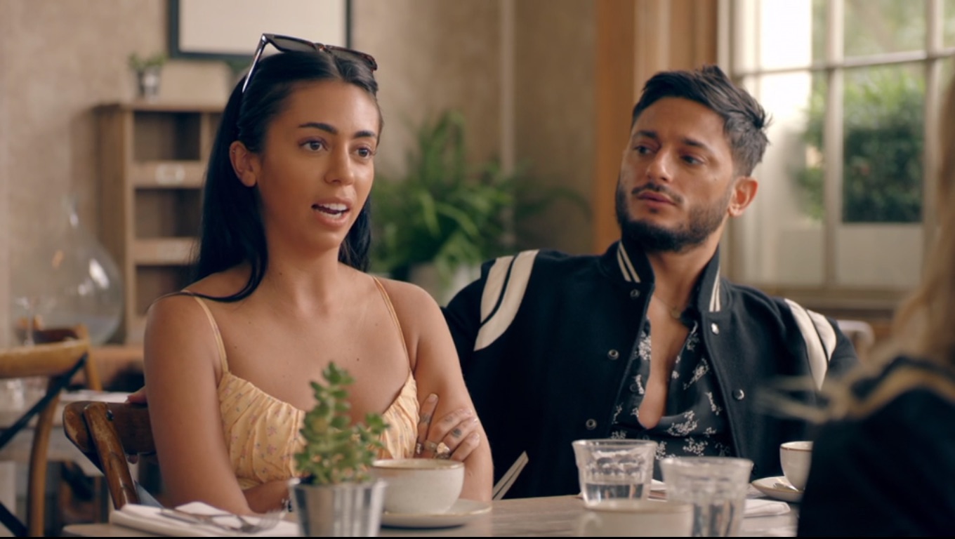 Ruby and Reza sitting at a table in Made In Chelsea